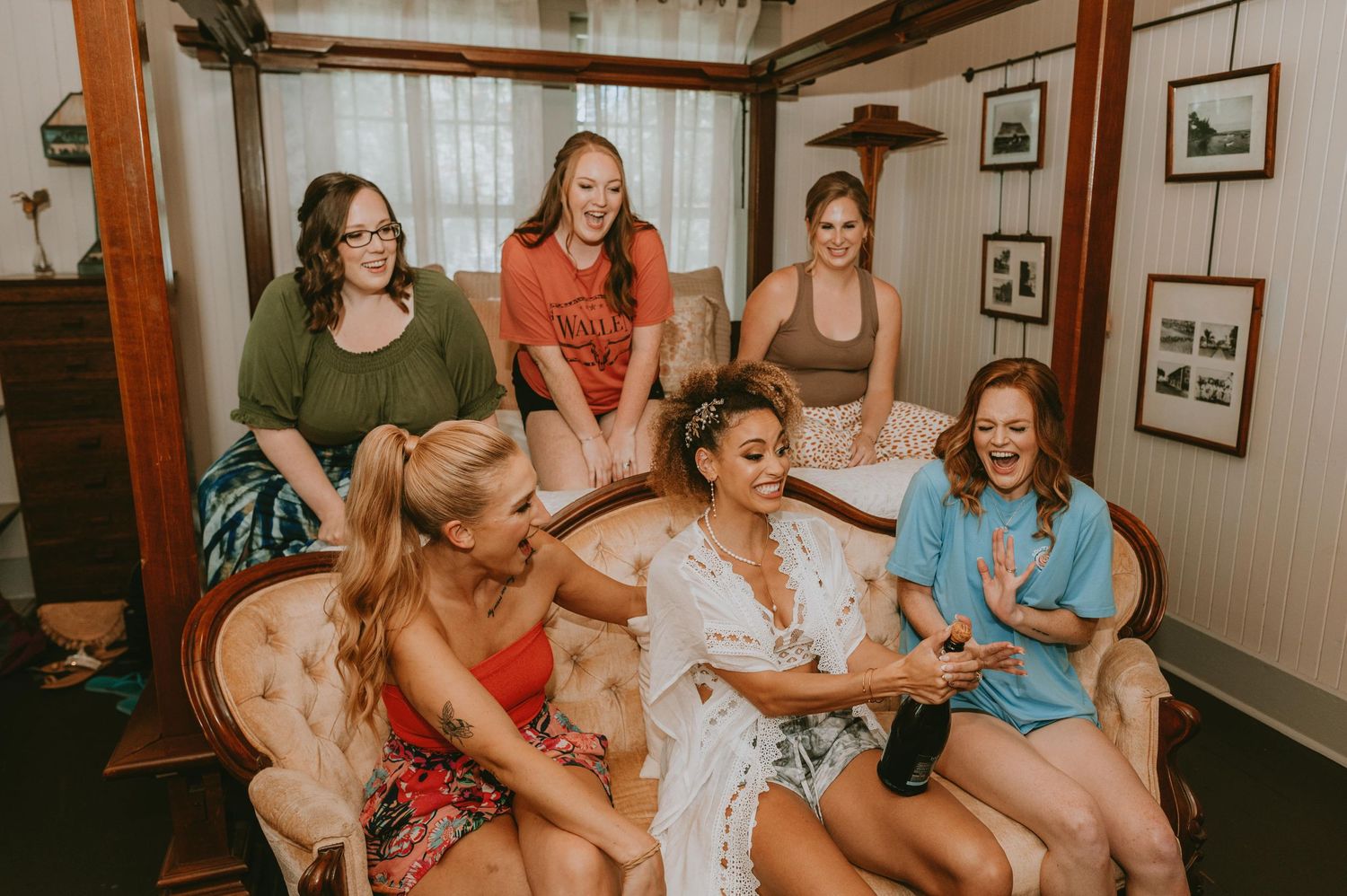 Friends sharing joyful moments and laughter while relaxing on indoor seating.