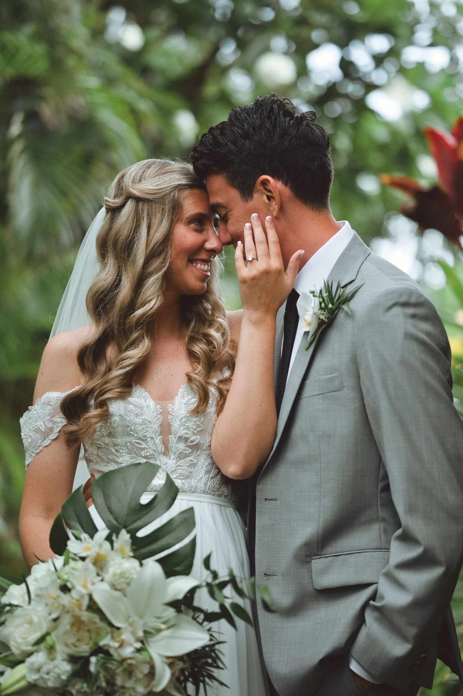 Emma and Matt share a close wedding portrait surrounded by tropical greenery at Sugar Beach Events.