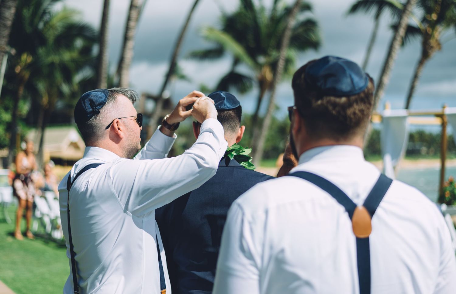 Wedding party members taking photos at a tropical beach location.
