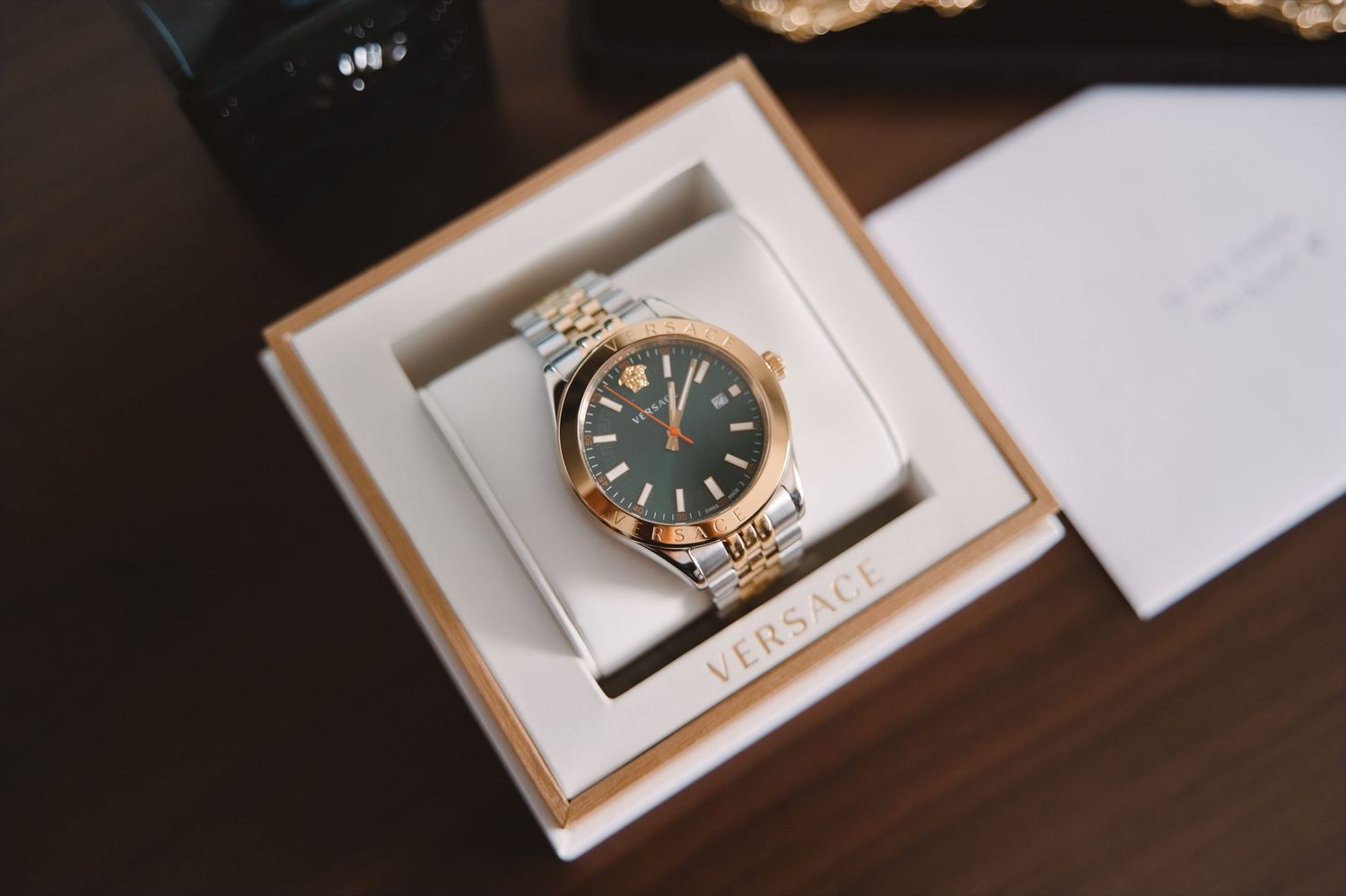 Versace two-tone rose gold and silver watch with green dial displayed in luxury white gift box.