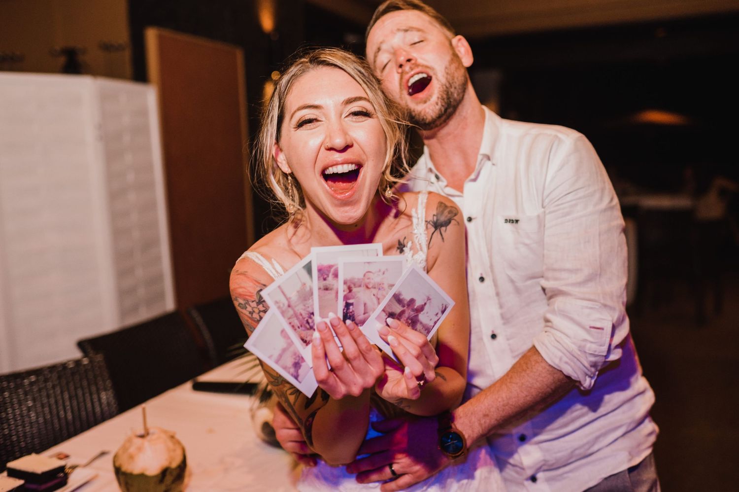 Excited couple laughing and holding cash money at a party celebration event indoors.
