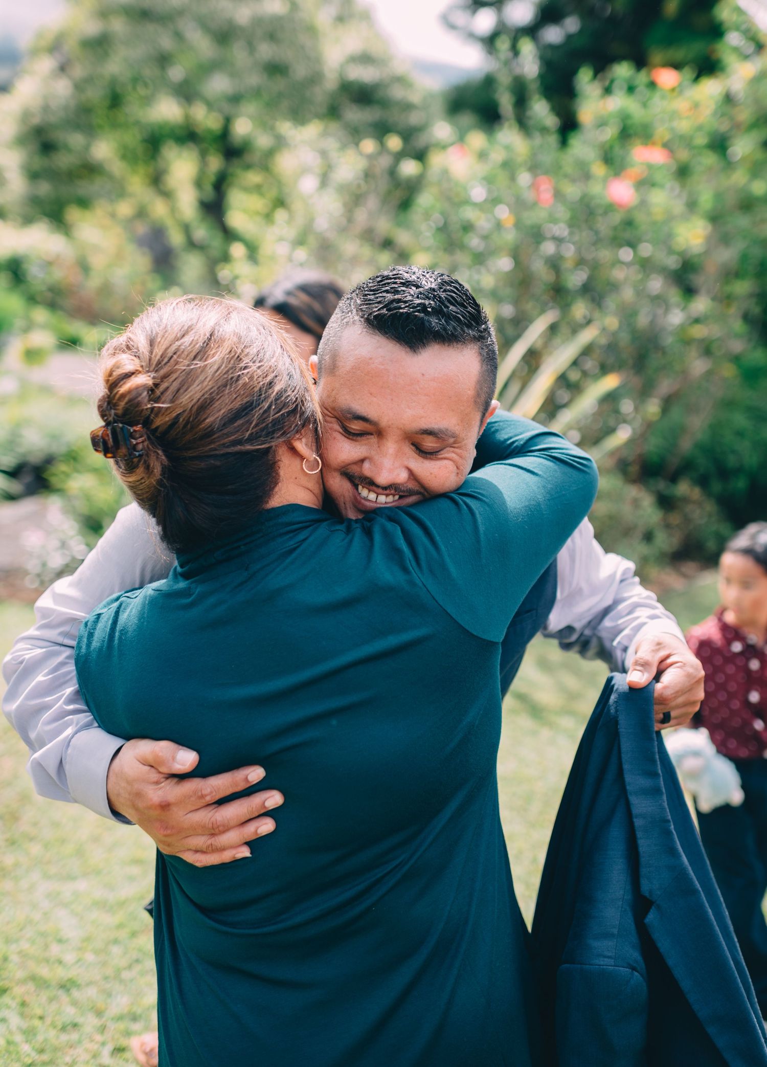 Emotional embraces shared between wedding attendees during an outdoor celebration.