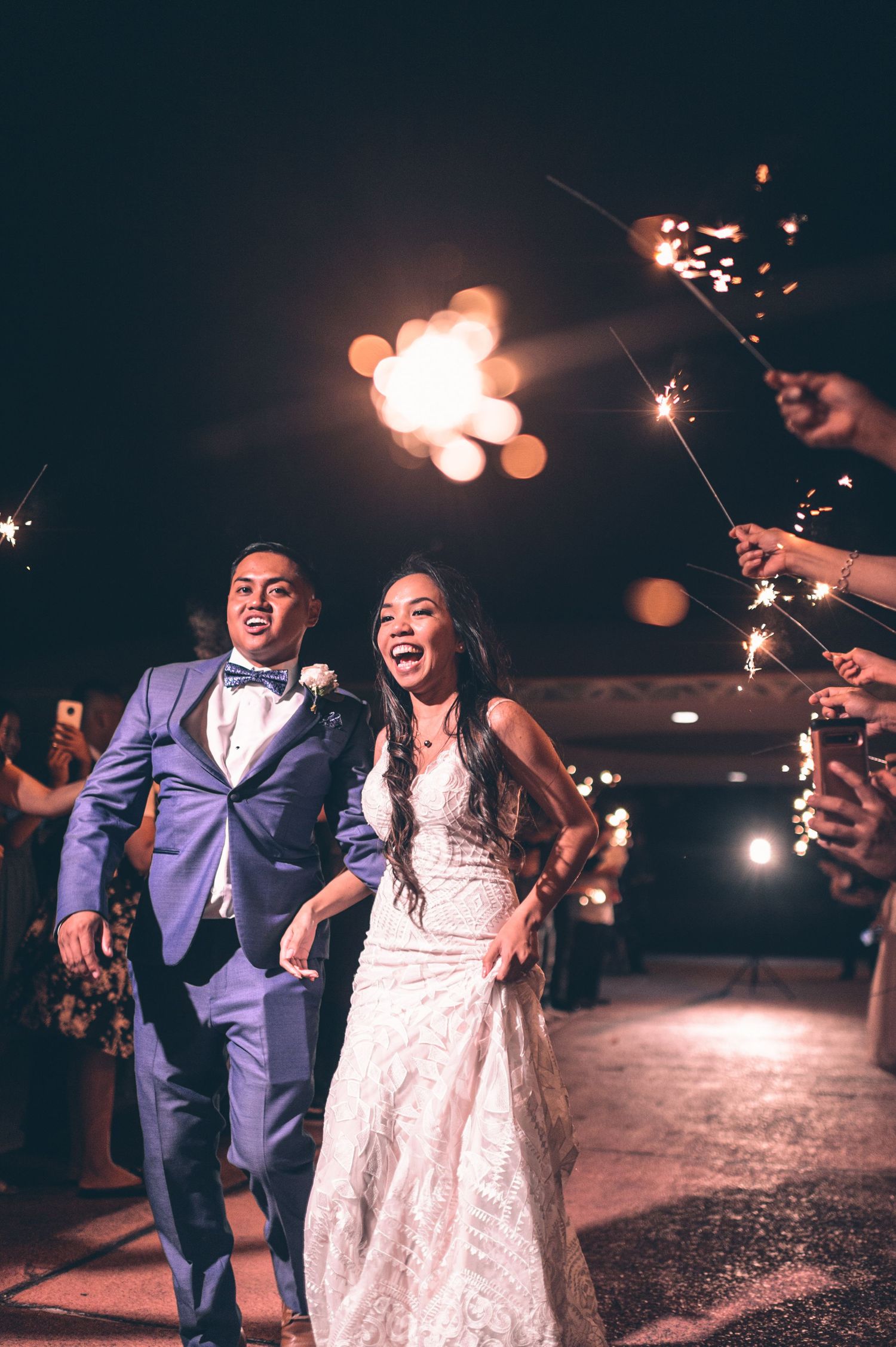 Newlyweds celebrate with sparklers during their nighttime wedding exit.