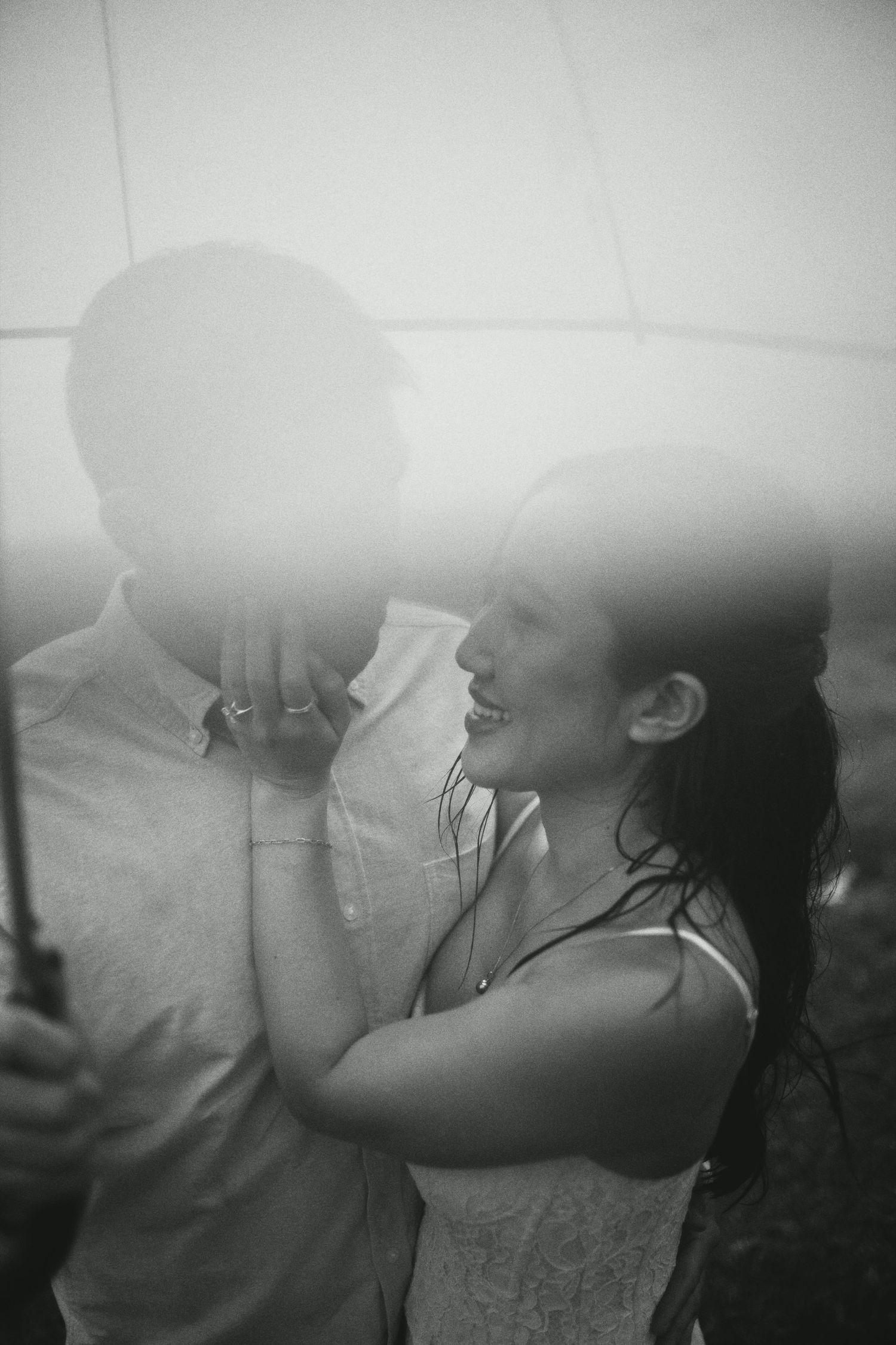 Black and white romantic photo of a couple sharing an intimate moment in soft light.