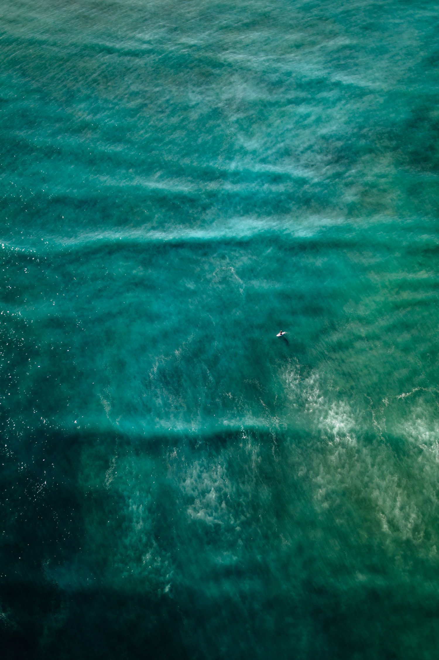 Turquoise ocean waters with gentle waves creating subtle patterns on the surface.
