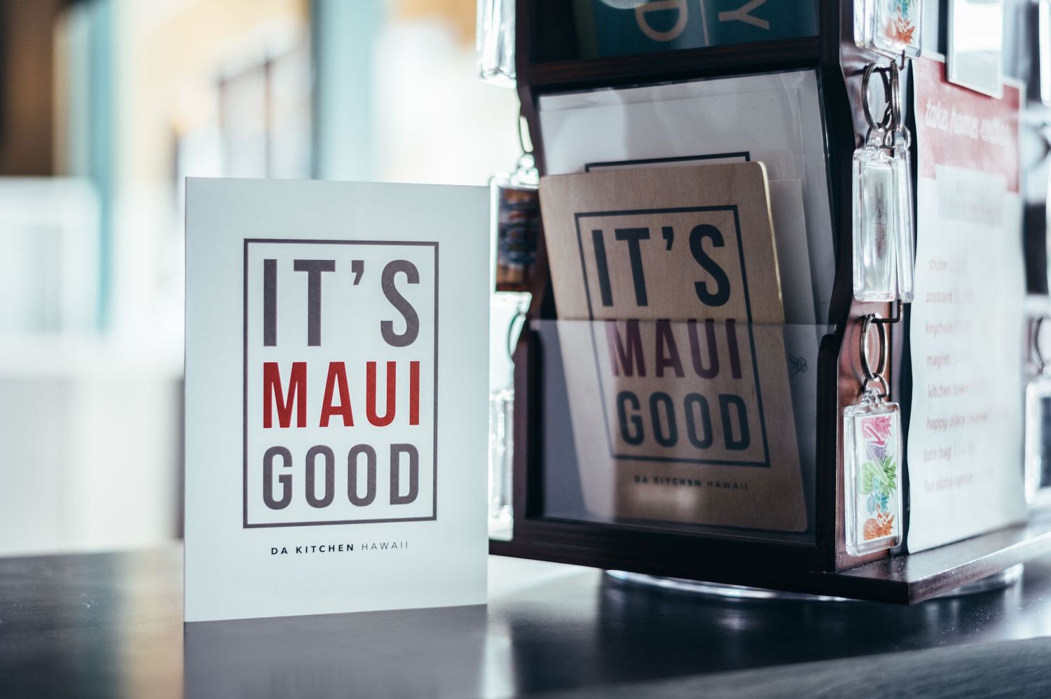 Two 'It's Maui Good' retail signs displayed in store setting.