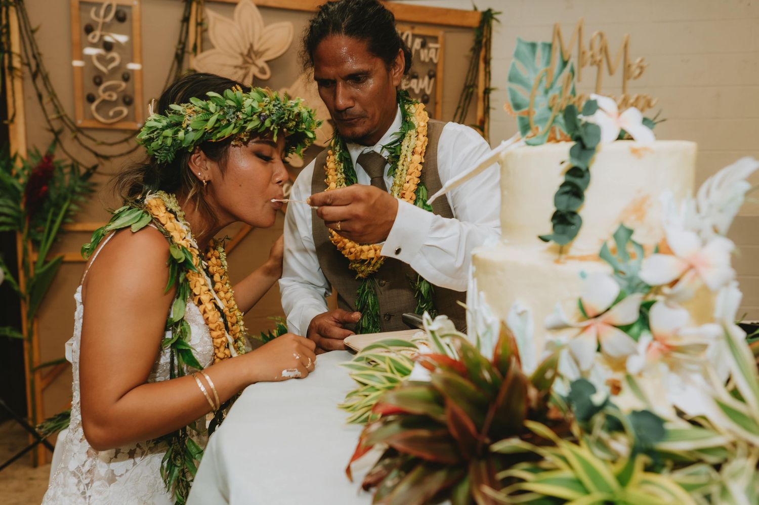 Wedding celebration with white orchid floral arrangements and tropical greenery.