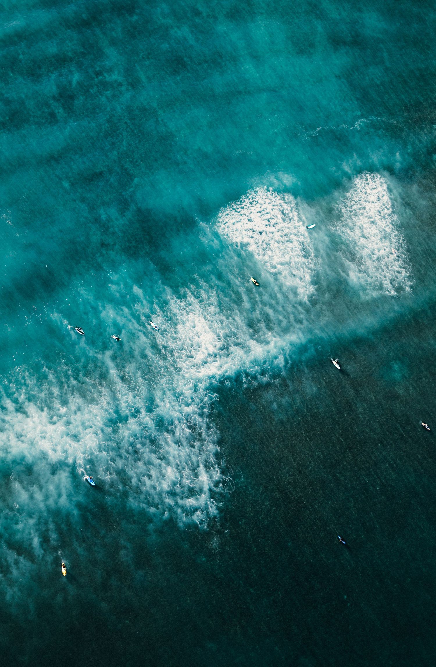 White ocean surf breaking against deep turquoise waters creating dramatic contrast.
