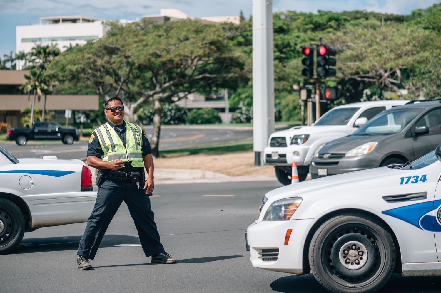 Police vehicles and officers monitor a street during a protest event.