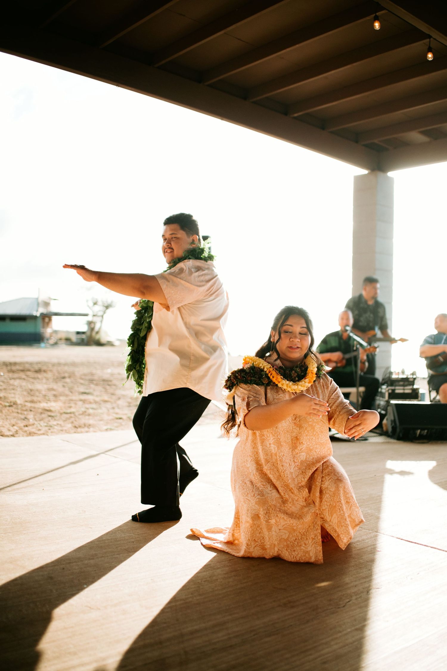 Morgan and Kaʻena dance hula with live musicians at their outdoor reception.