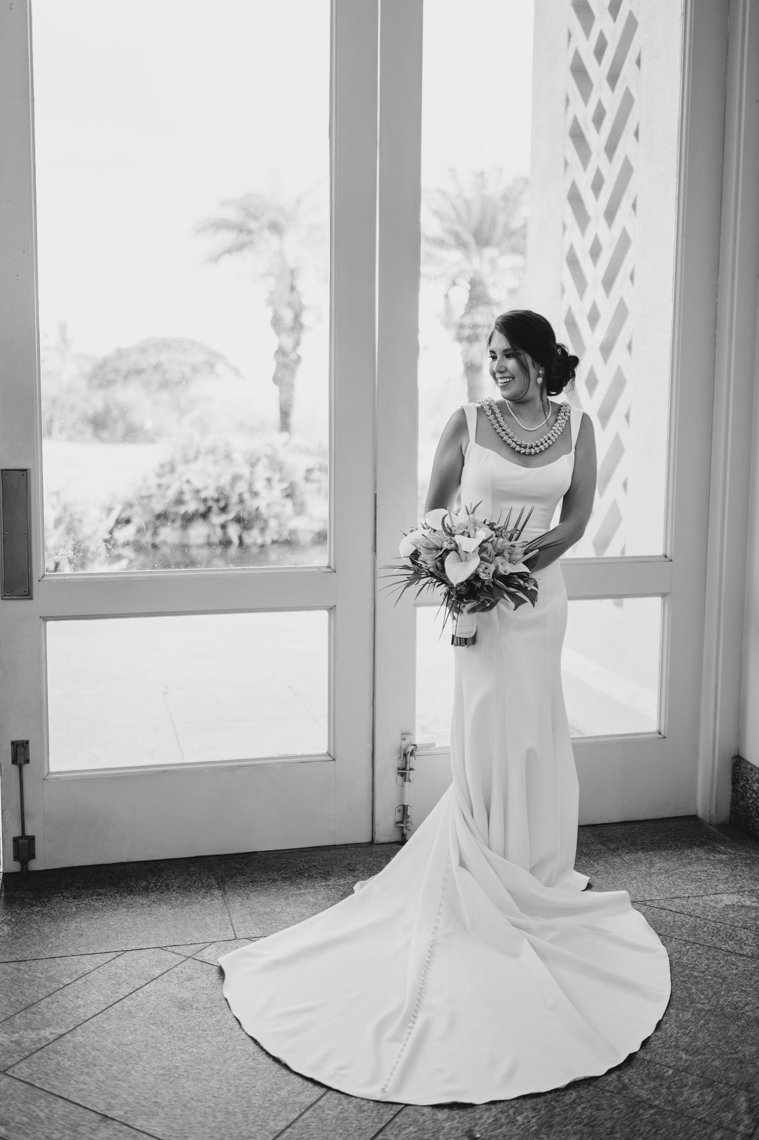 Elegant bridal portraits in black and white showing a flowing wedding dress train.