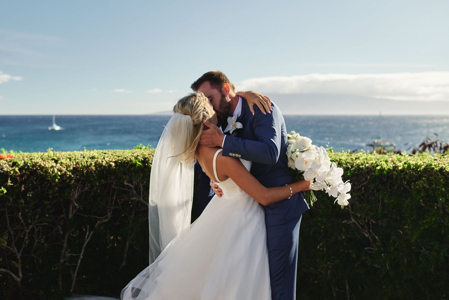 Newlyweds share romantic moments against a stunning ocean backdrop.