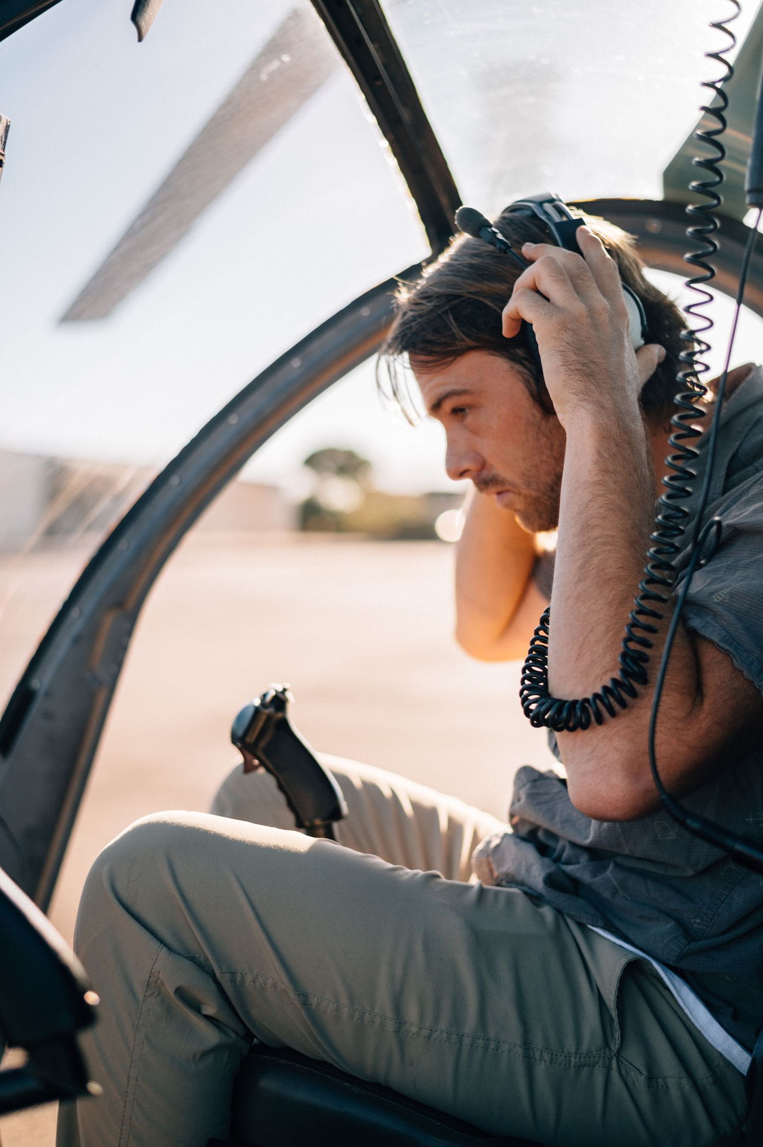 Pilot performing radio communications check inside helicopter cockpit.