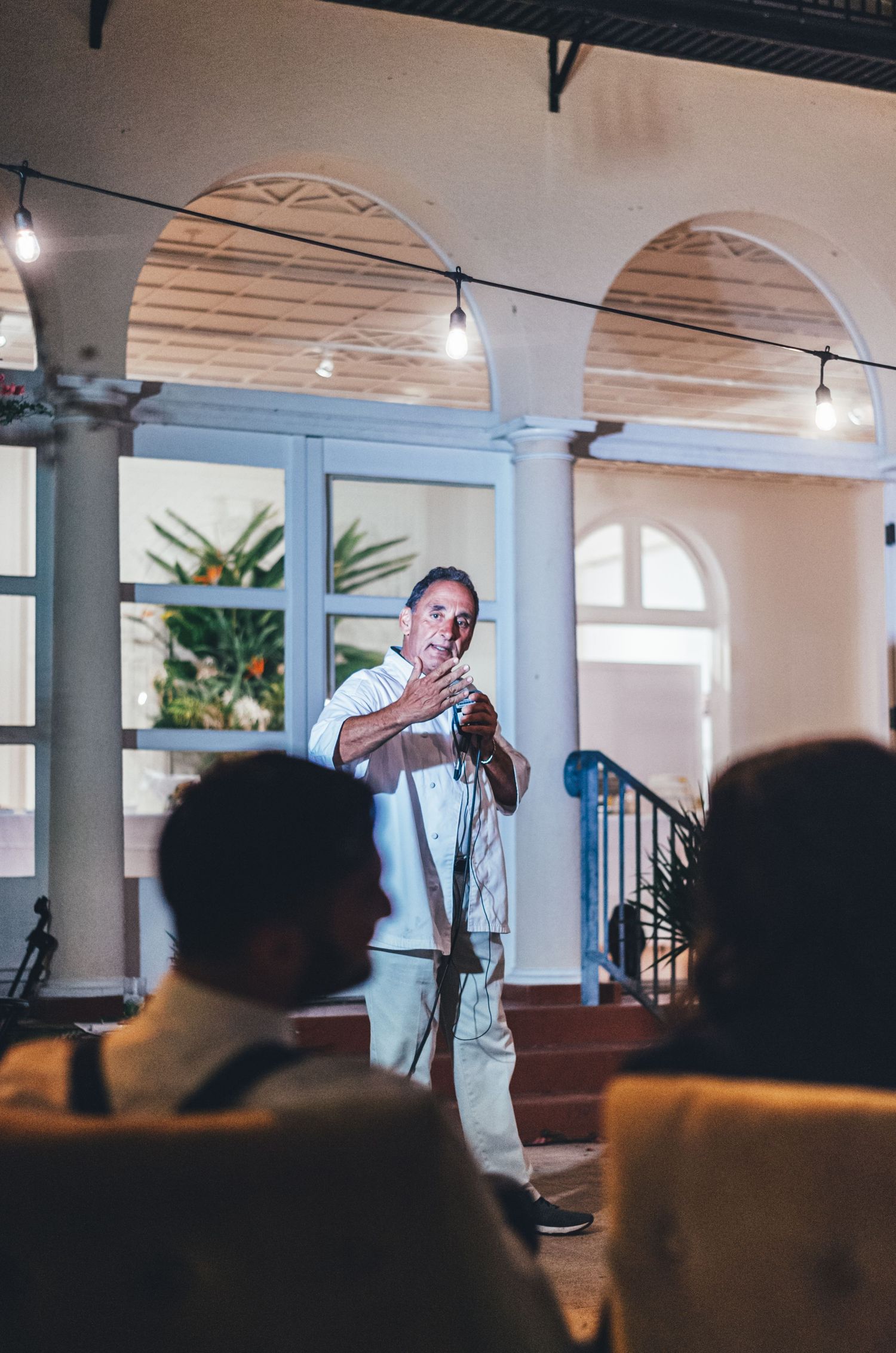 Wedding ceremony space with arched windows and indoor palm plants.