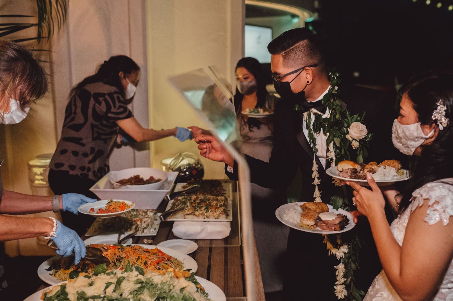 Wedding reception guests enjoying a buffet dinner service at an indoor venue.