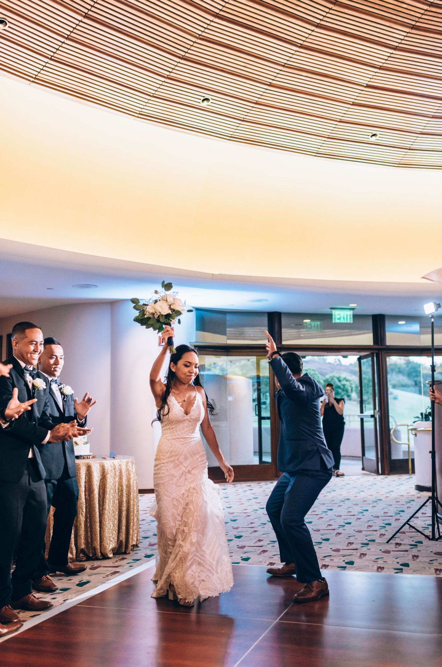 Celebratory dance sequence unfolds in elegant reception space with curved architectural details.