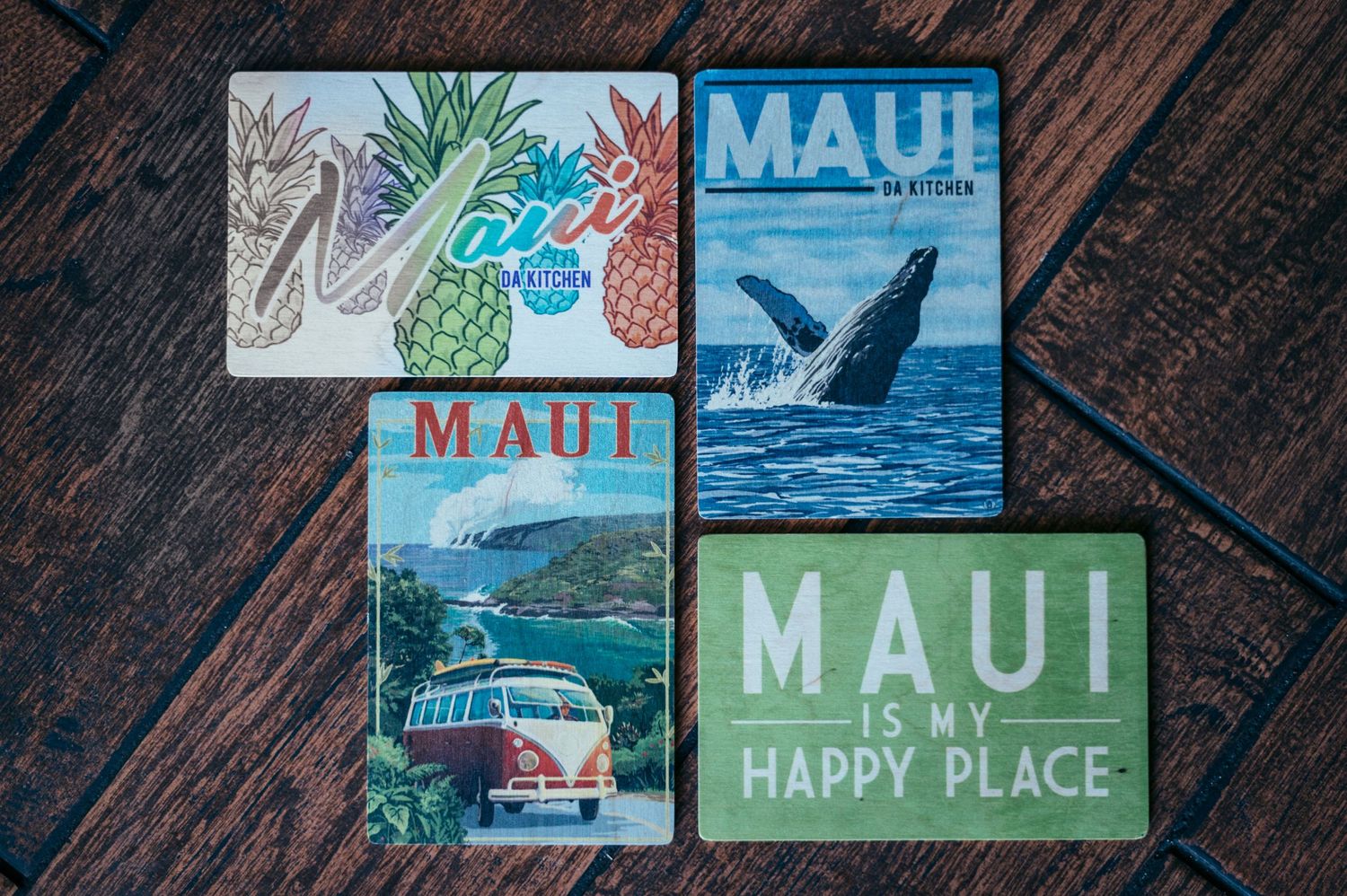 Collection of Maui-themed decorative magnets featuring whales, surf vans, and island scenery.