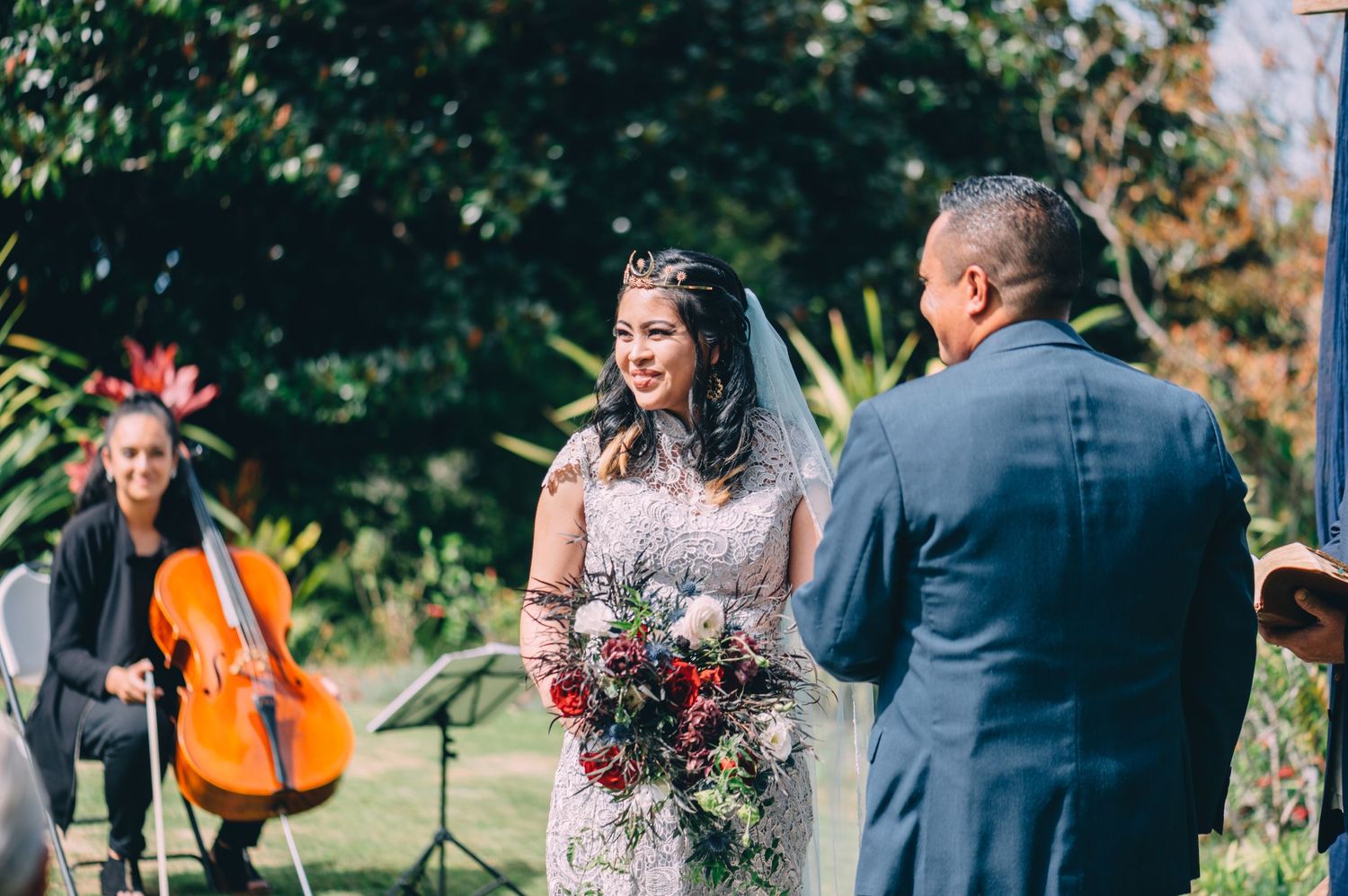 Wedding ceremony in progress at a scenic outdoor garden venue with floral arrangements.