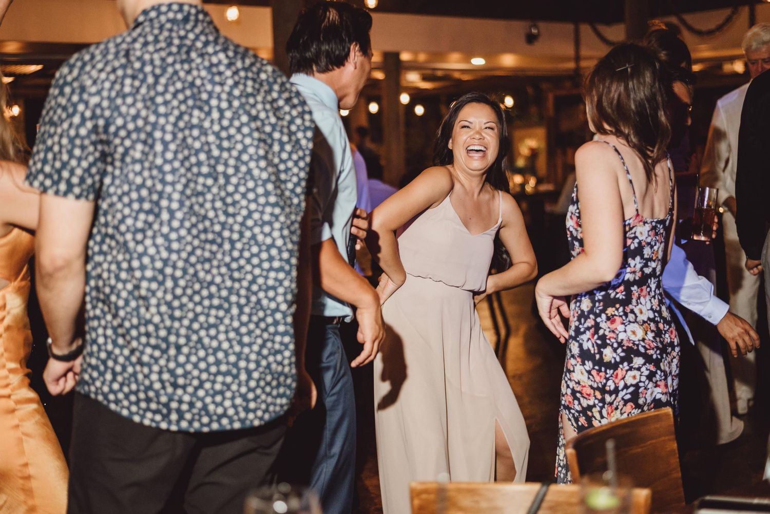 Wedding guests enjoying themselves on the dance floor during evening reception.