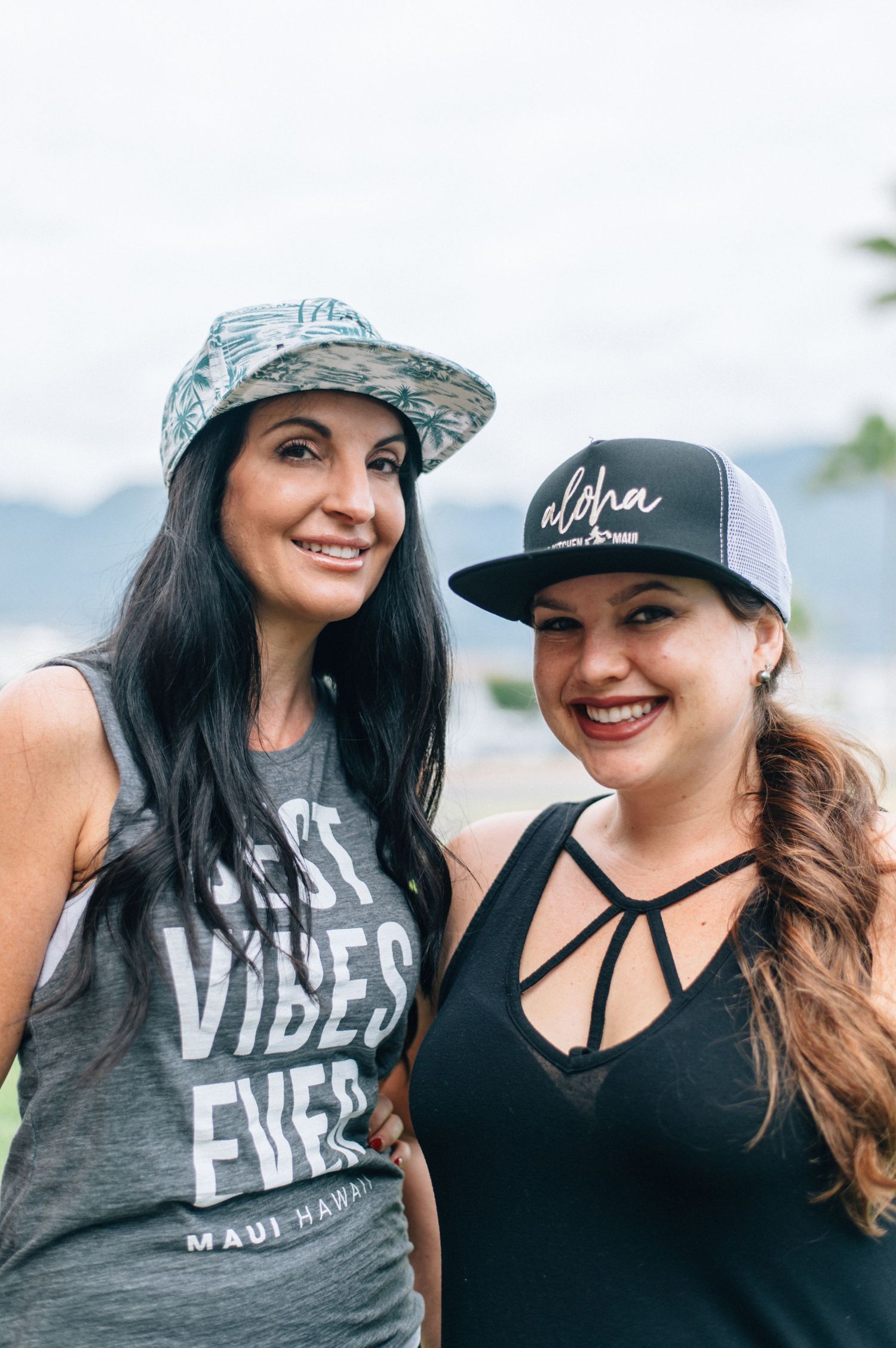Two friends wearing casual graphic t-shirts and hats outdoors.