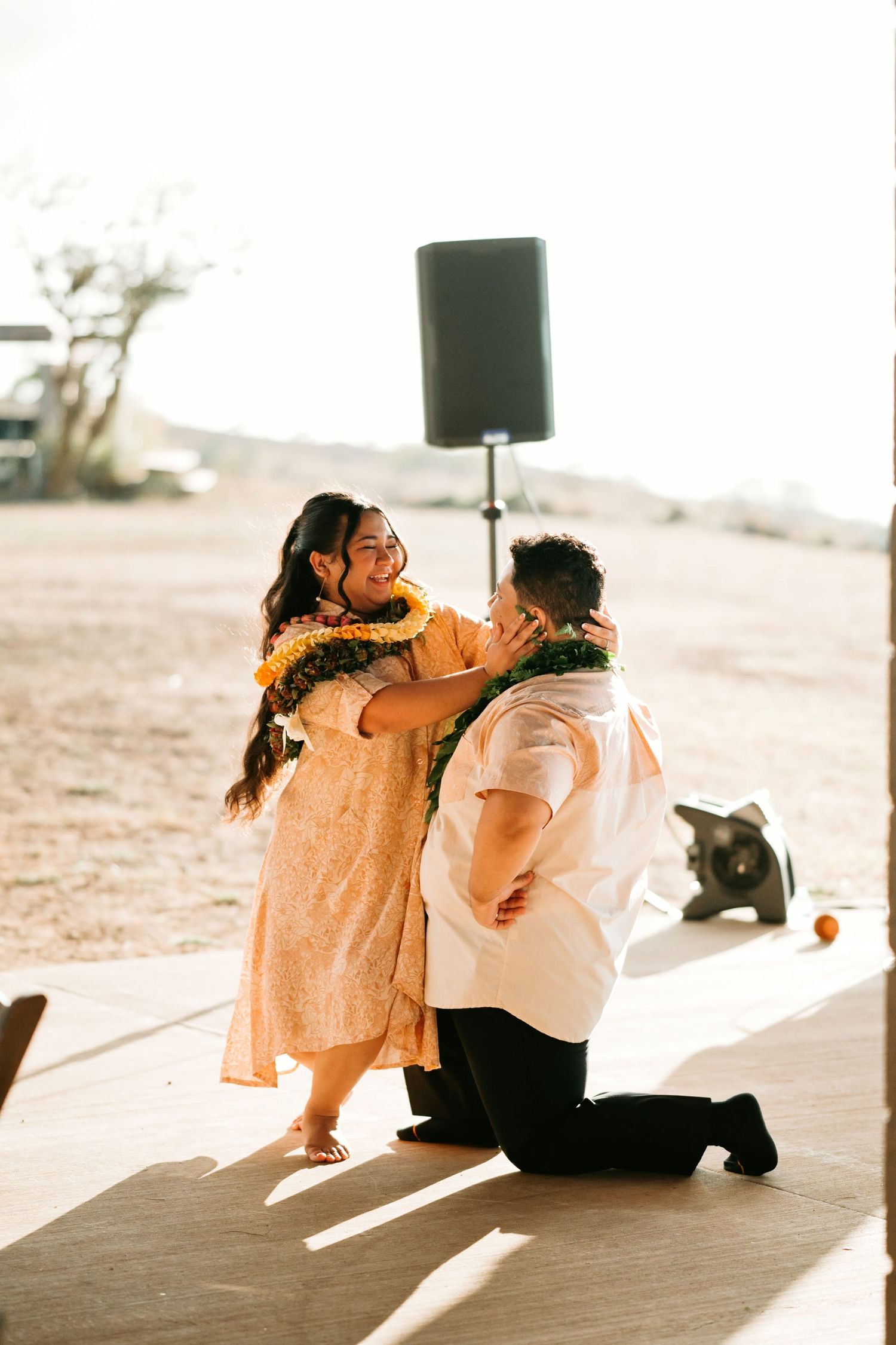 Morgan kneels toward Kaʻena during their reception dance.