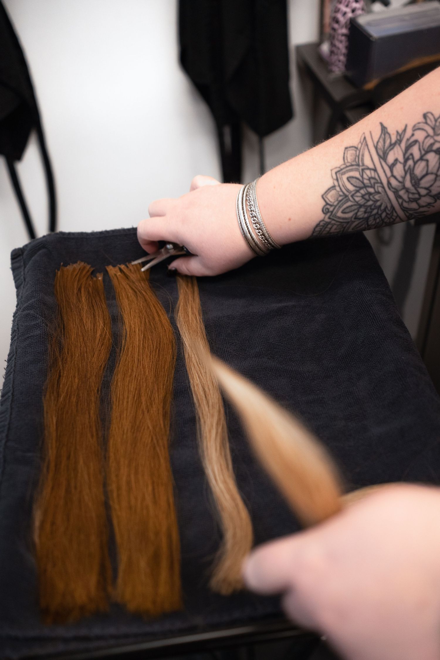 Stylist blending natural hair with extensions, hair salon branding photography