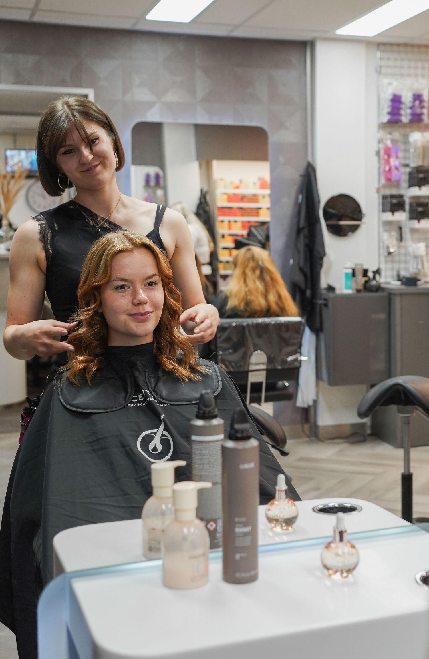 Client admiring finished hairstyle in salon mirror, hair salon commercial photography