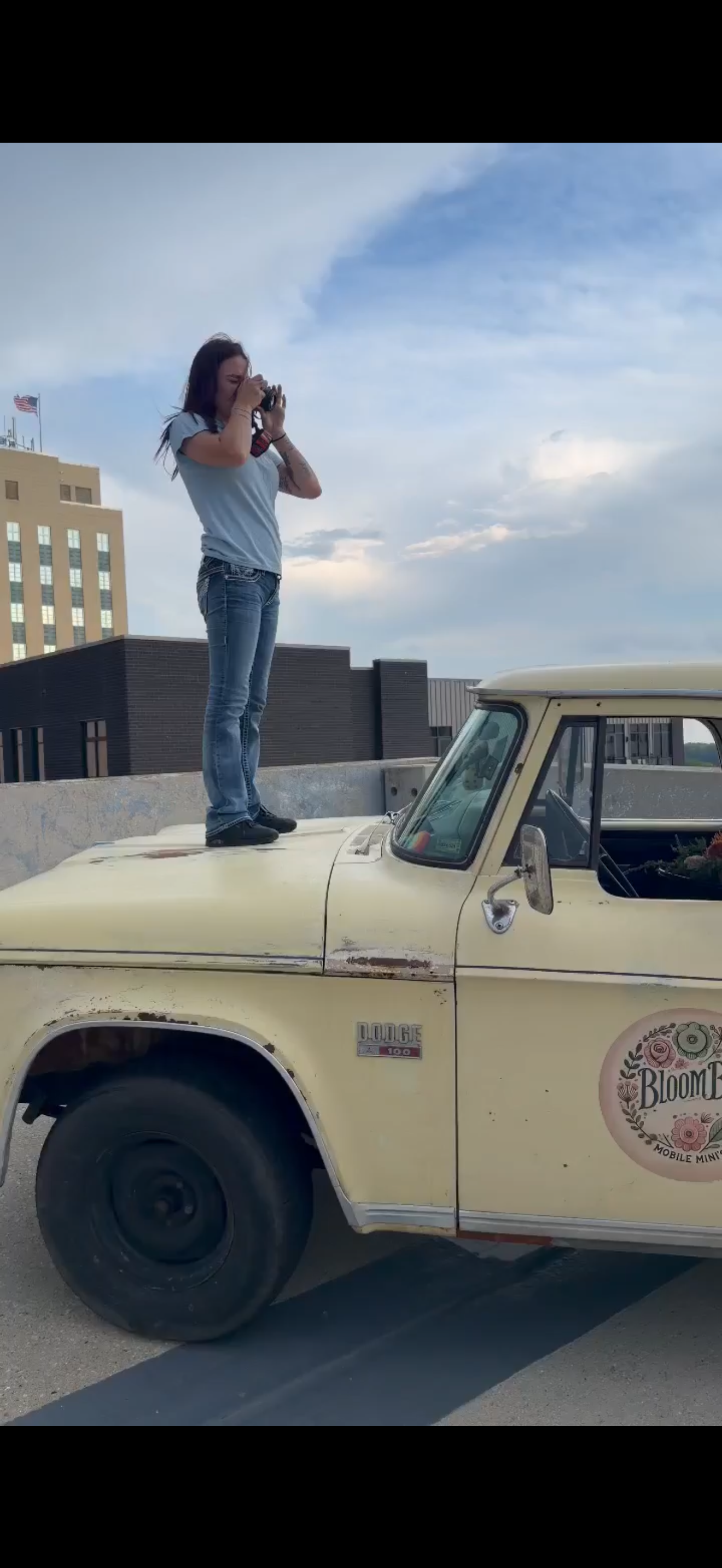 Photographer standing on a truck to capture a unique angle