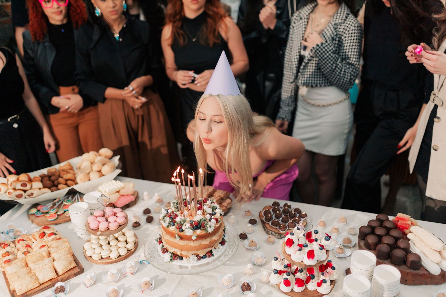 Guests celebrating around a dessert table at a special event
