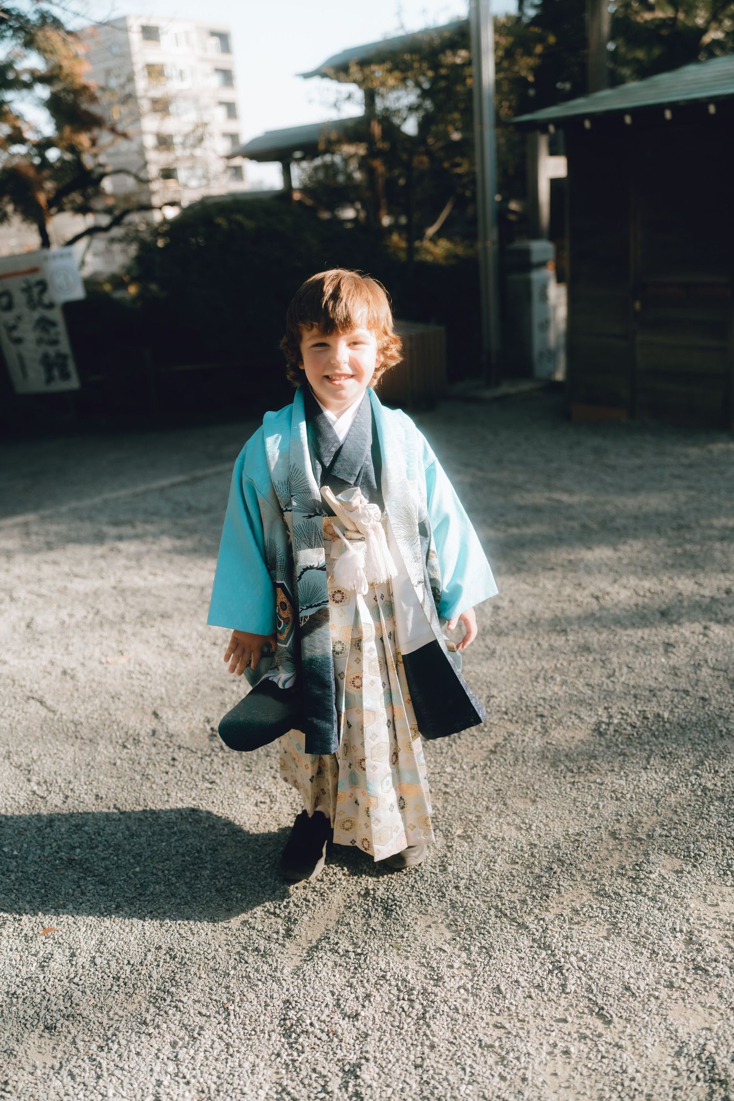 A young child wearing a traditional teal haori and hakama for Shichi-Go-San at Iseyama Kotai Jingu in Yokohama, Japan.