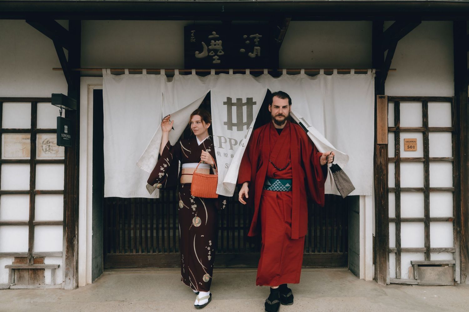 Couple in traditional Japanese kimono walking through a temple gate in Japan.