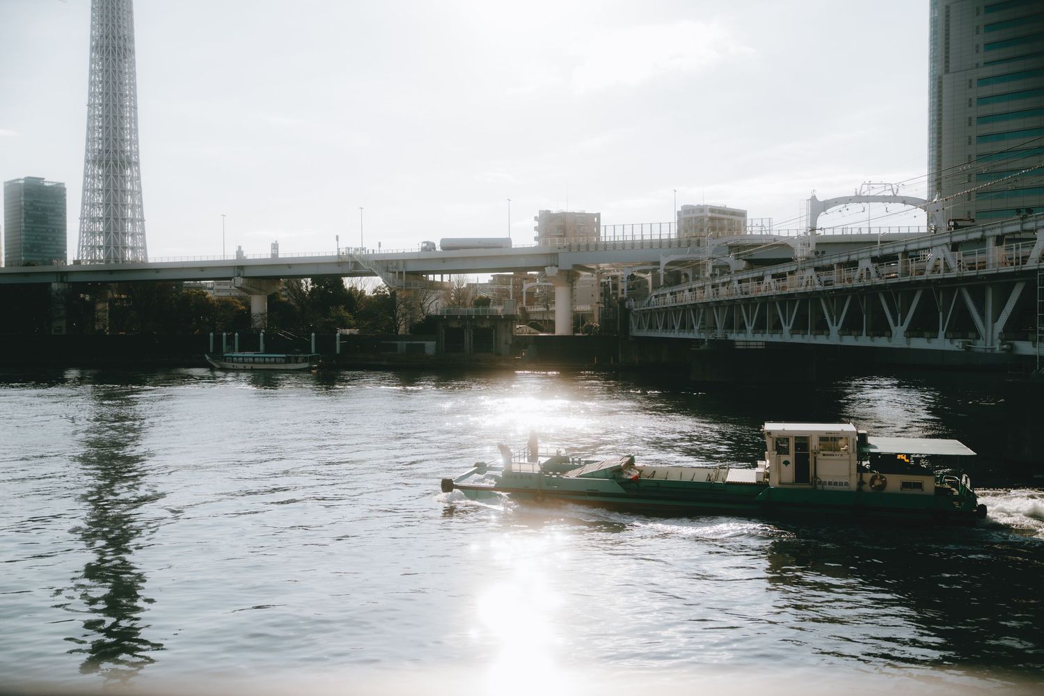 Boats on sumida river near bridges in asakusa, tokyo.