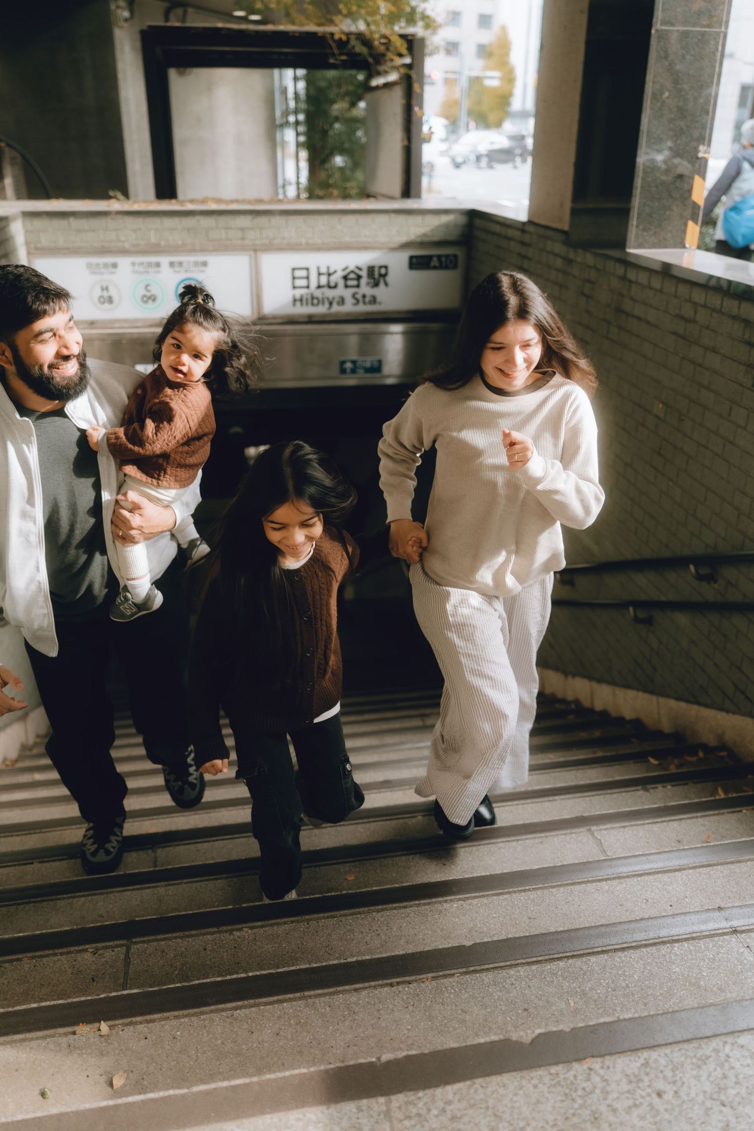 Happy family climbing stairs at Hibiya Station in Tokyo, Japan.