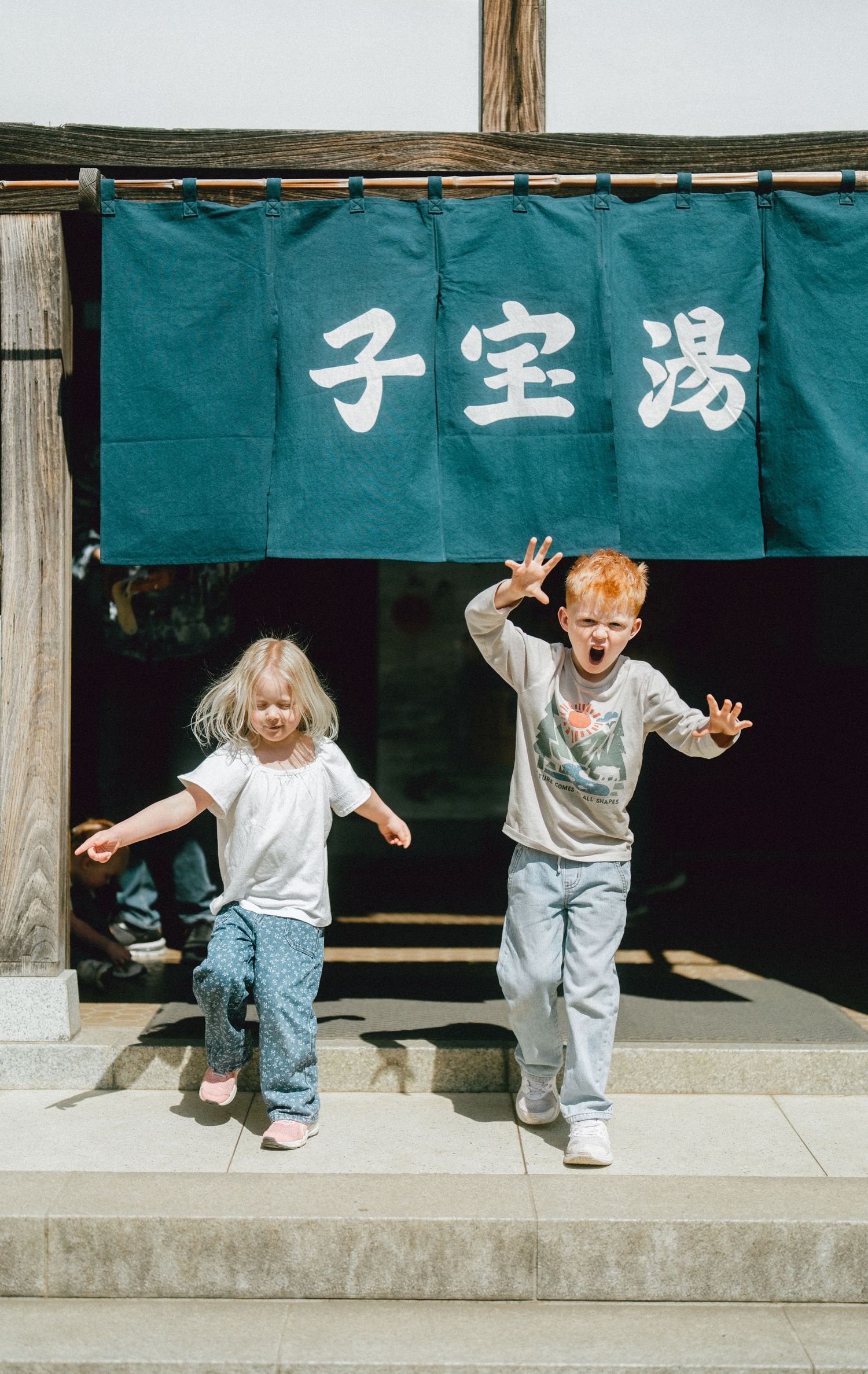 Family walking through a traditional Japanese streetscape at the Edo-Tokyo Open Air Architectural Museum in Tokyo, Japan.