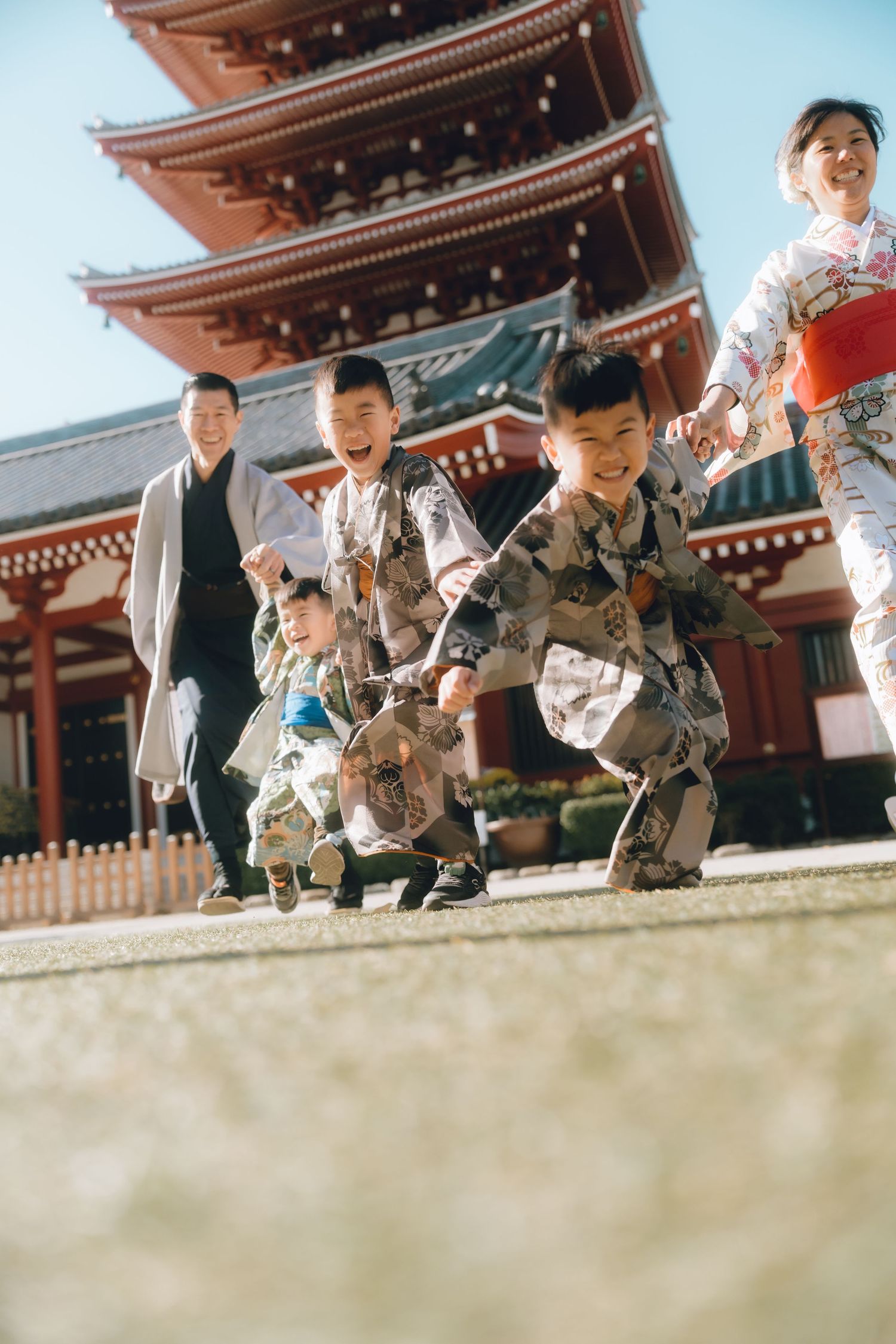 Japanese family in traditional kimono laughing and running together at Senso-ji Temple, Tokyo.