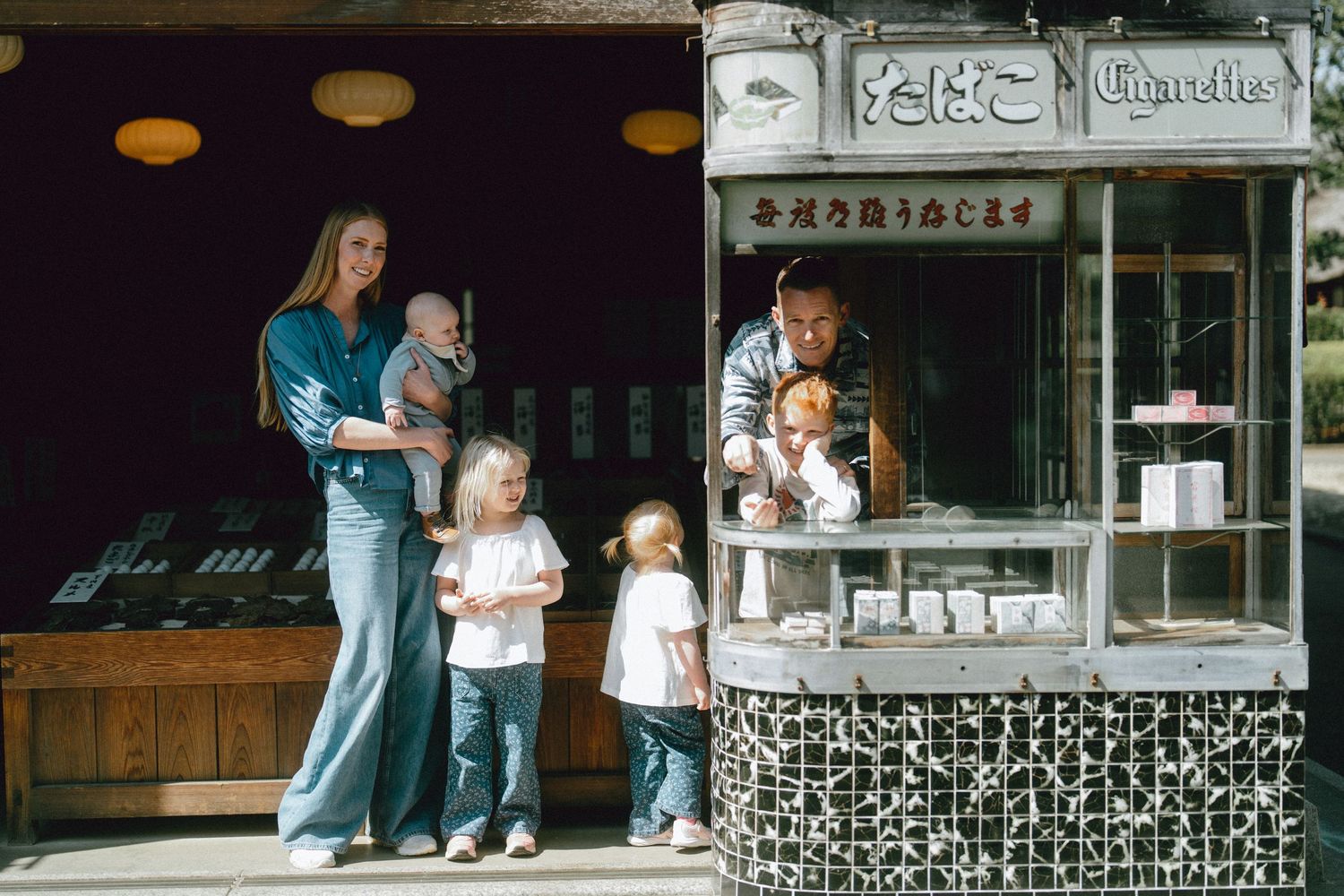 Family walking through a traditional Japanese streetscape at the Edo-Tokyo Open Air Architectural Museum in Tokyo, Japan.