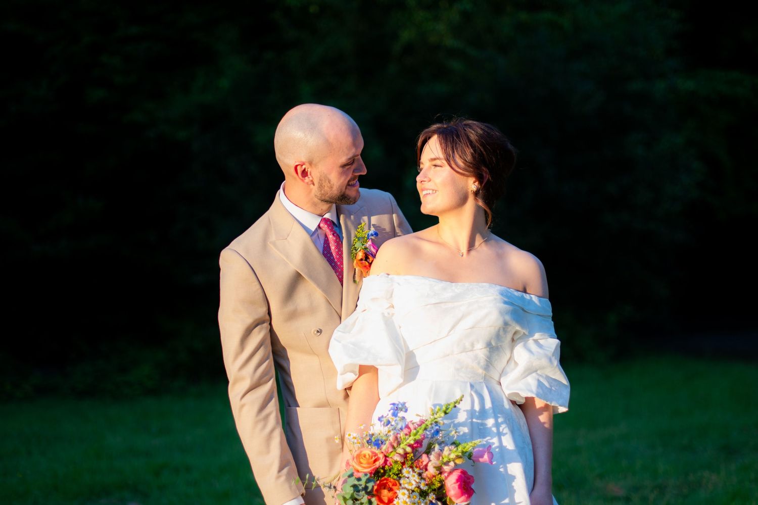 Portrait photo of the wedding couple looking at eachother, it is sharp with high contrast and a blurry background.