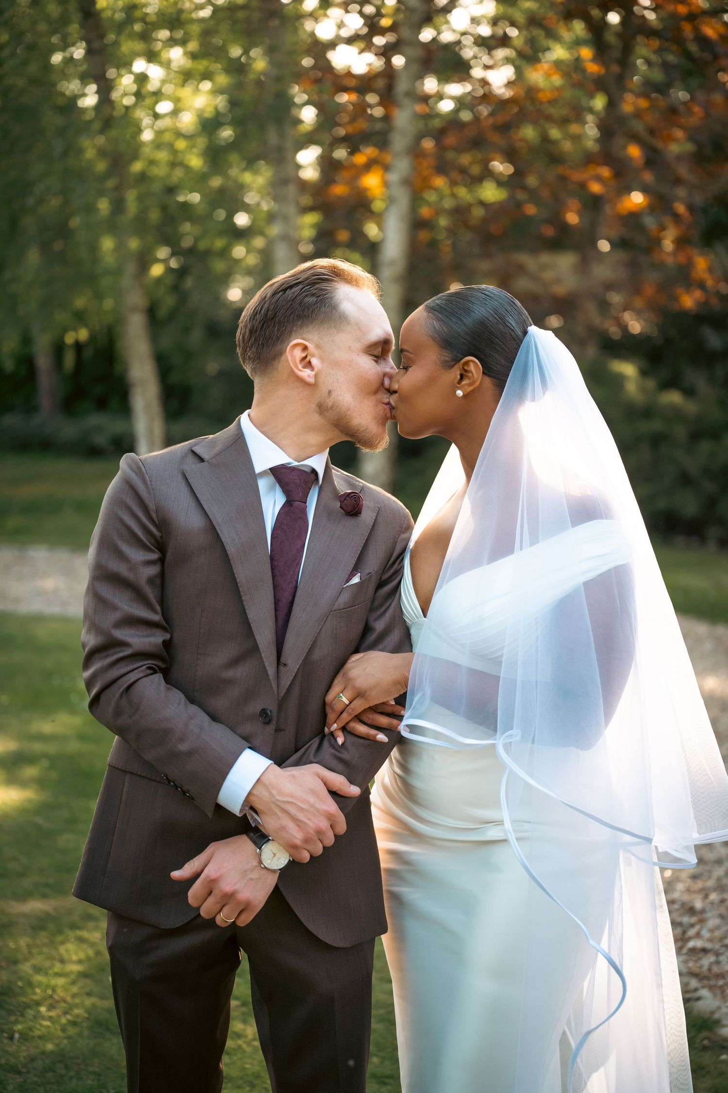 Portrait photo of the wedding couple kissing, it is sharp with high contrast and a blurry background.