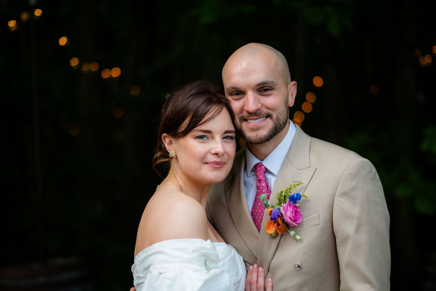 Portrait photo of the wedding couple posing looking at the camera, it is sharp with high contrast and a blurry background.