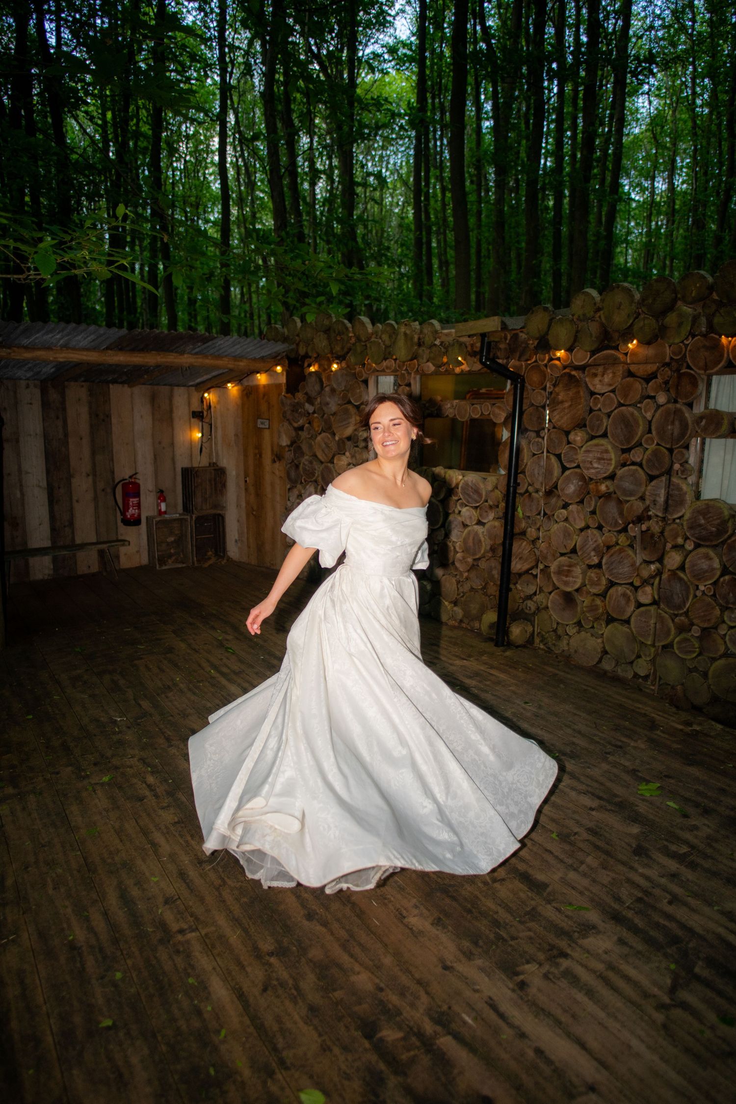 Portrait photo of the wedding bride dancing twirling her dress, it is sharp with high contrast and a blurry background.