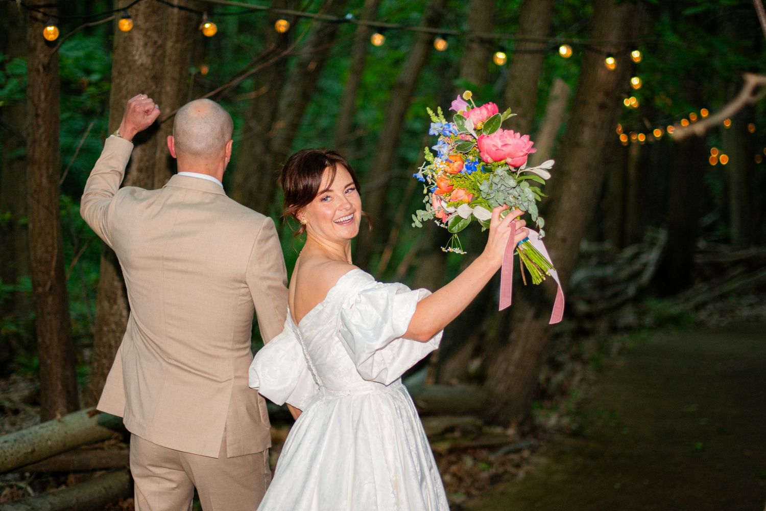 Portrait photo of the wedding walking off into woods, it is sharp with high contrast and a blurry background.