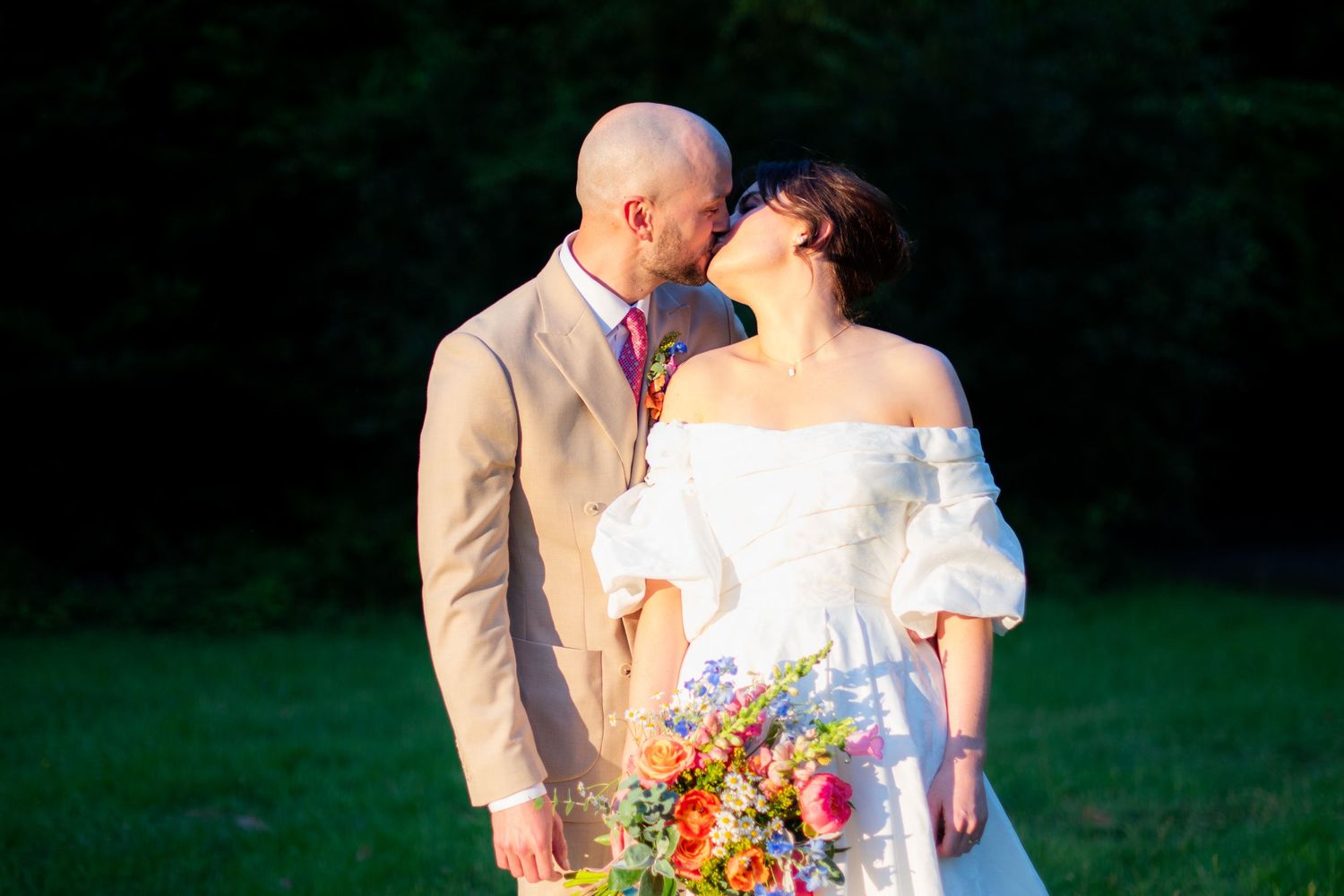 Portrait photo of the wedding couple kissing, it is sharp with high contrast and a blurry background.