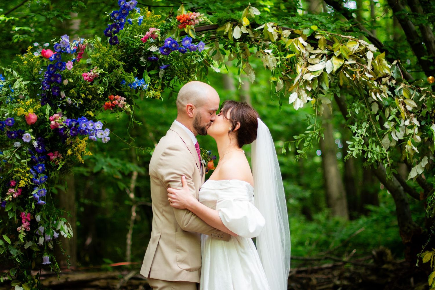 Portrait photo of the wedding couple kissing, it is sharp with high contrast and a blurry background.