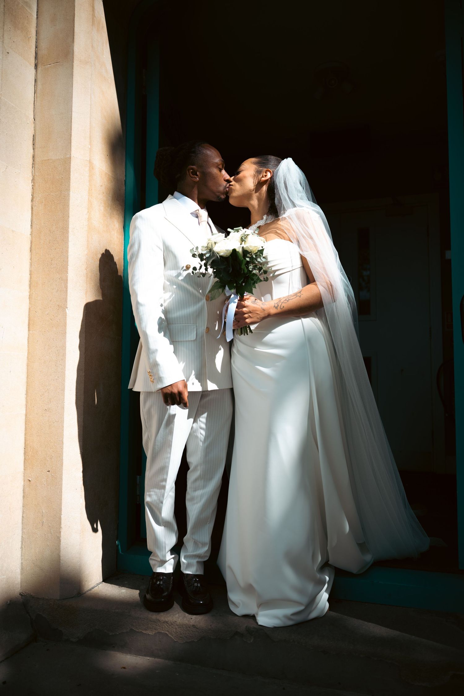 Portrait photo of the wedding couple kissing, it is sharp with high contrast and a blurry background.