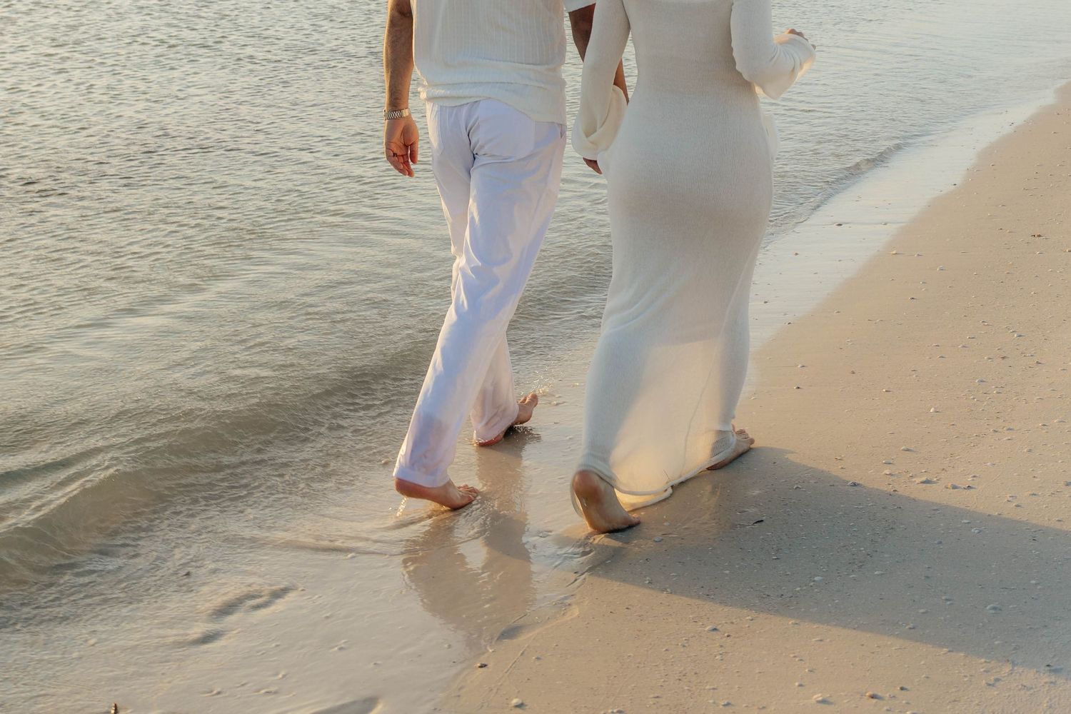 Couple walking along the shoreline during portrait session