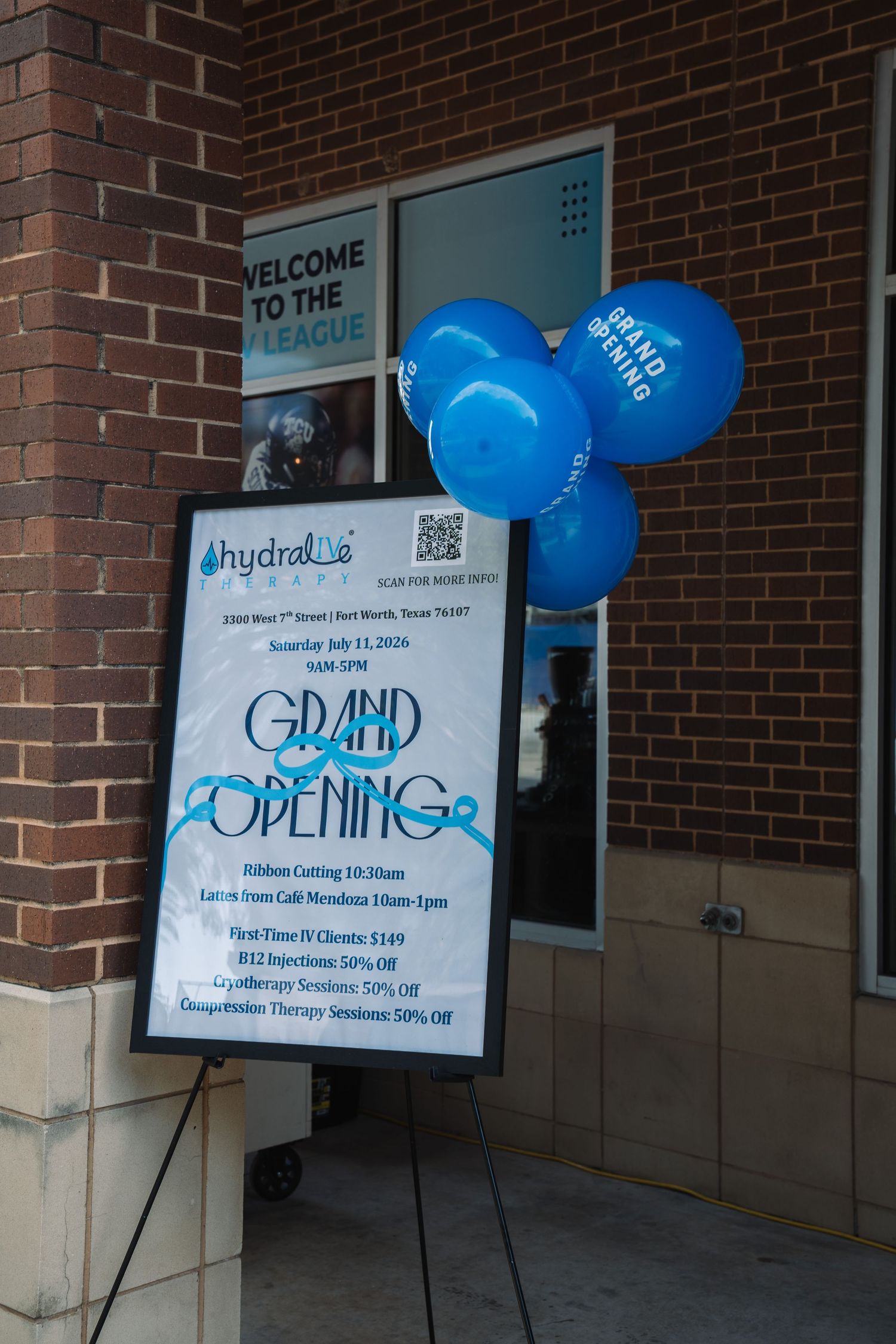 Grand Opening sign for Hydraline with blue balloons outside a brick building in Fort Worth, Texas.