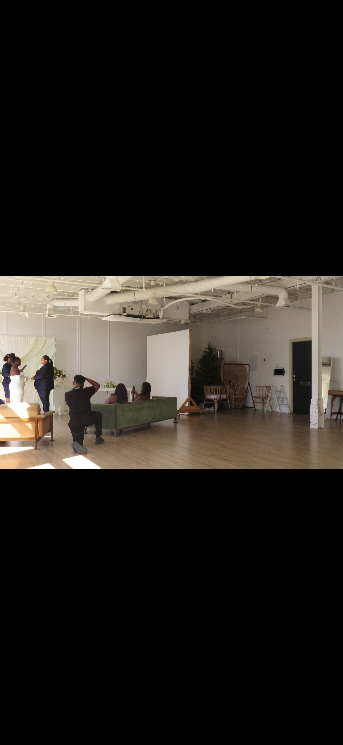 Spacious studio space with white walls and wood floors during an indoor photography session.