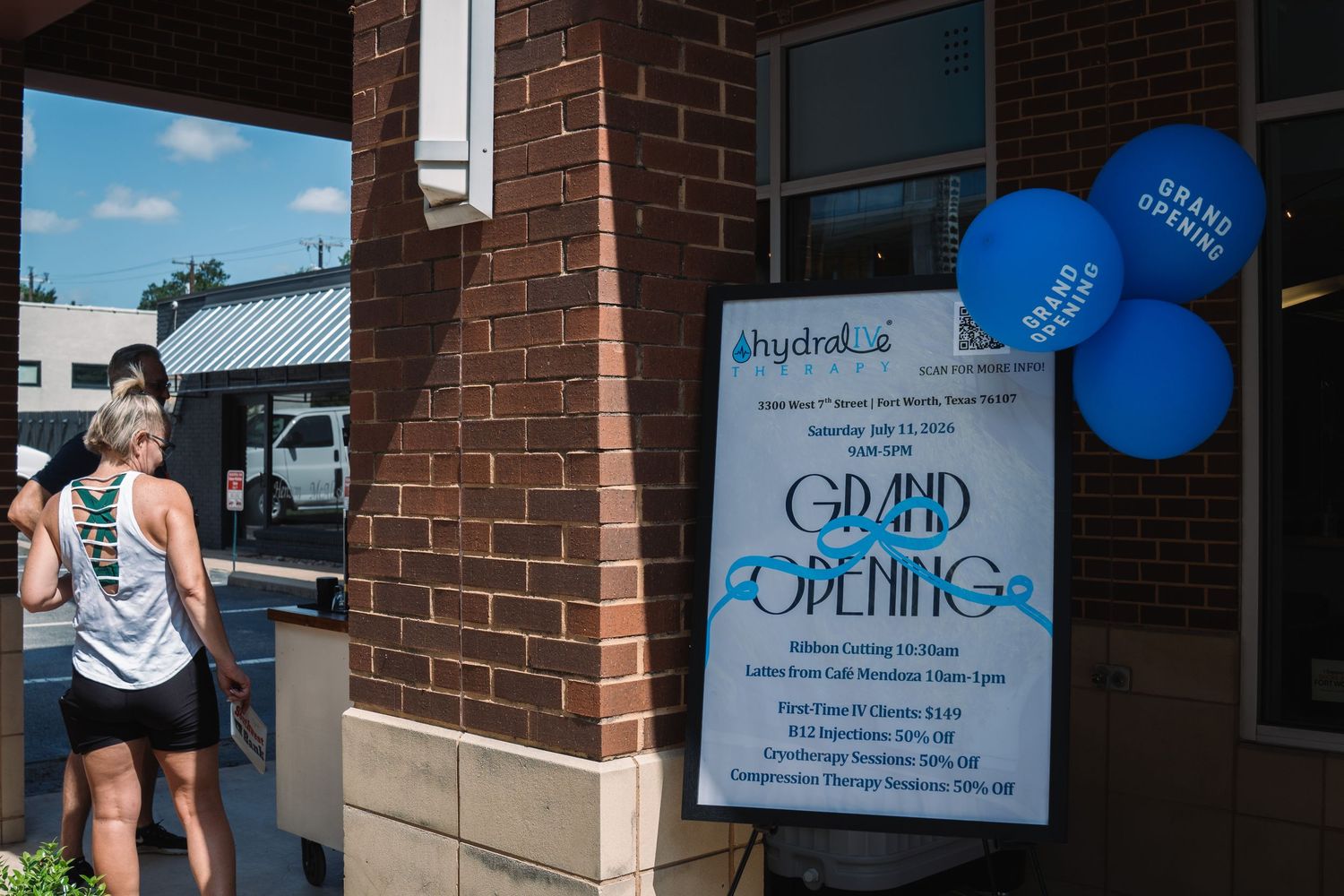 Grand opening celebration at Hydraloe with blue balloons and signage welcoming visitors to the new location on a sunny day.