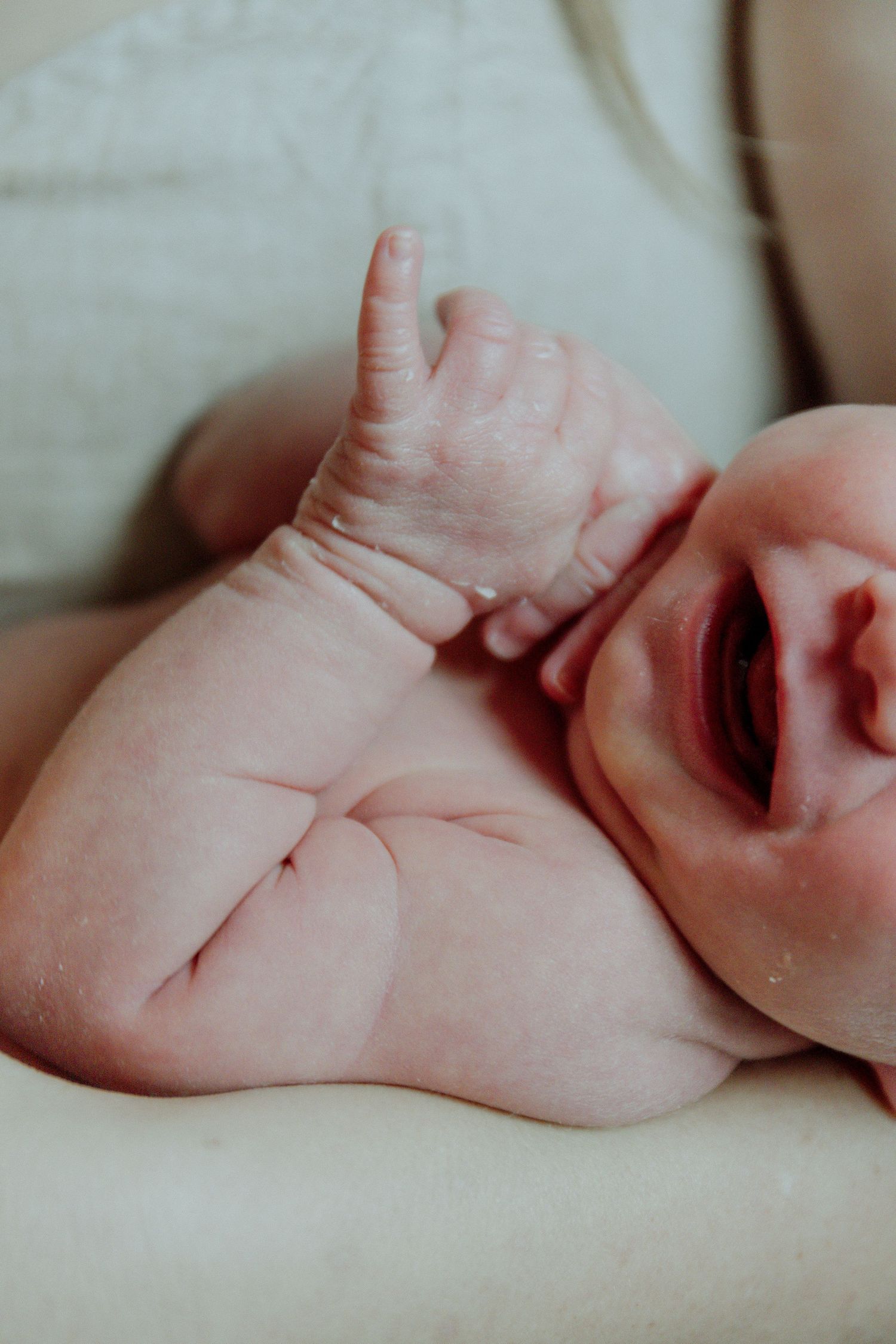 Kawartha Lakes Newborn Photography Session.
Close up detail photo of baby girl yawning while mom is holding her close