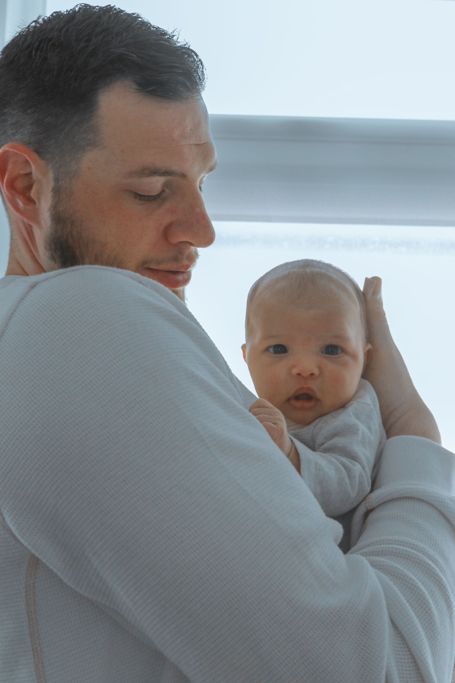 Kawartha Lakes Newborn Photography Session.
Dad holding baby girl newborn daughter. Looking at camera